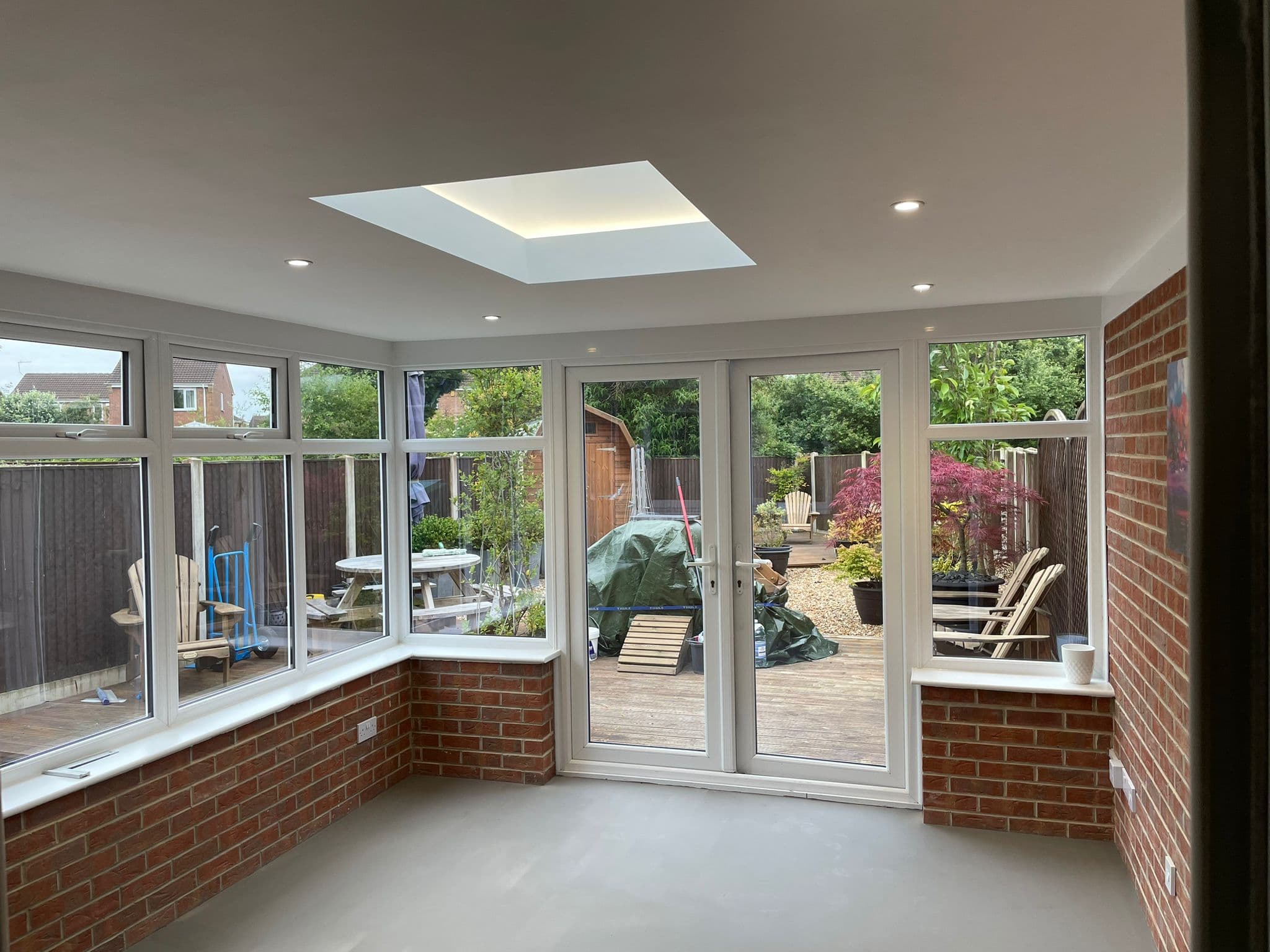 Conservatory with French doors, dwarf brick wall and flush rooflight