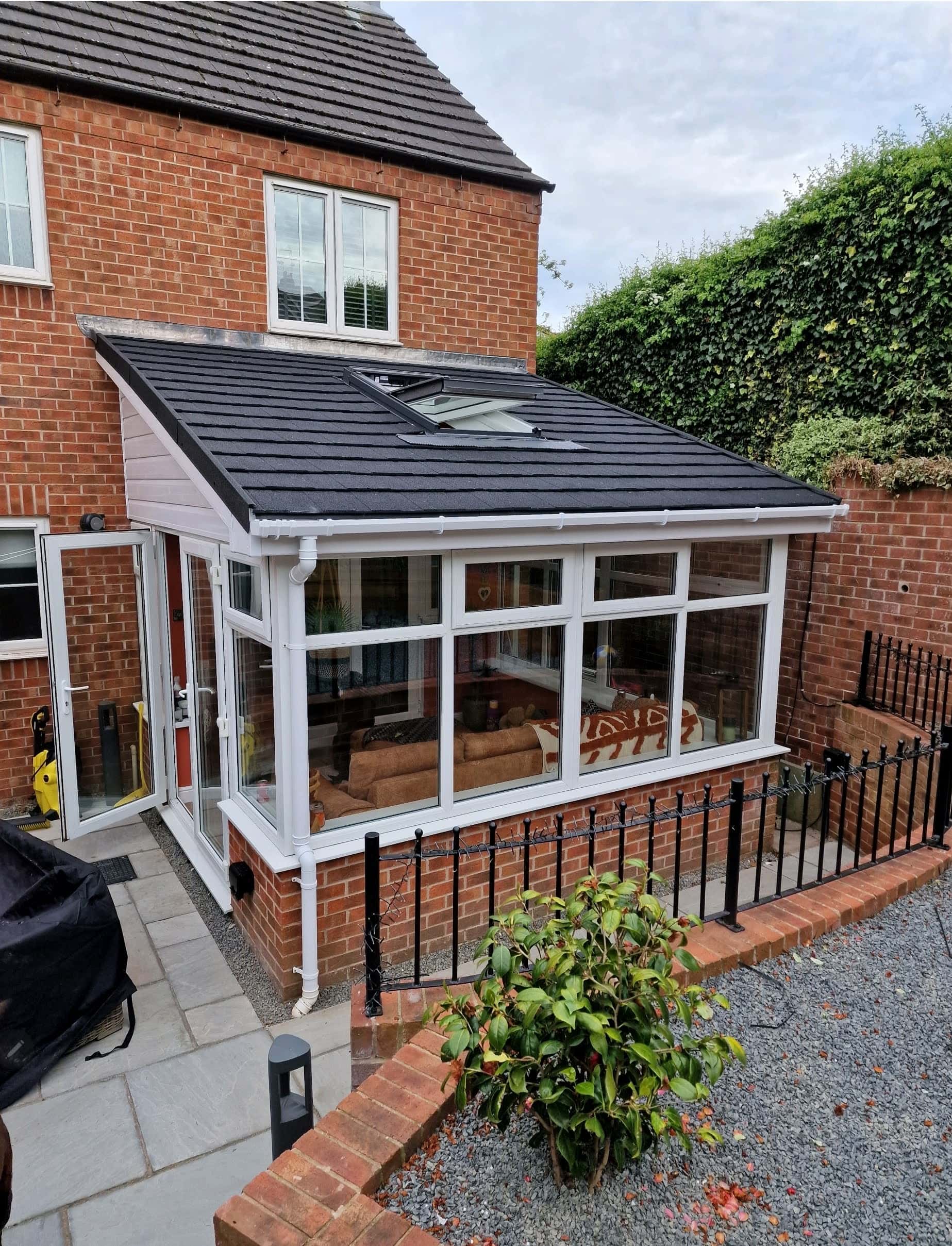 Lean-to conservatory with a new grey tiled warm roof and roof window