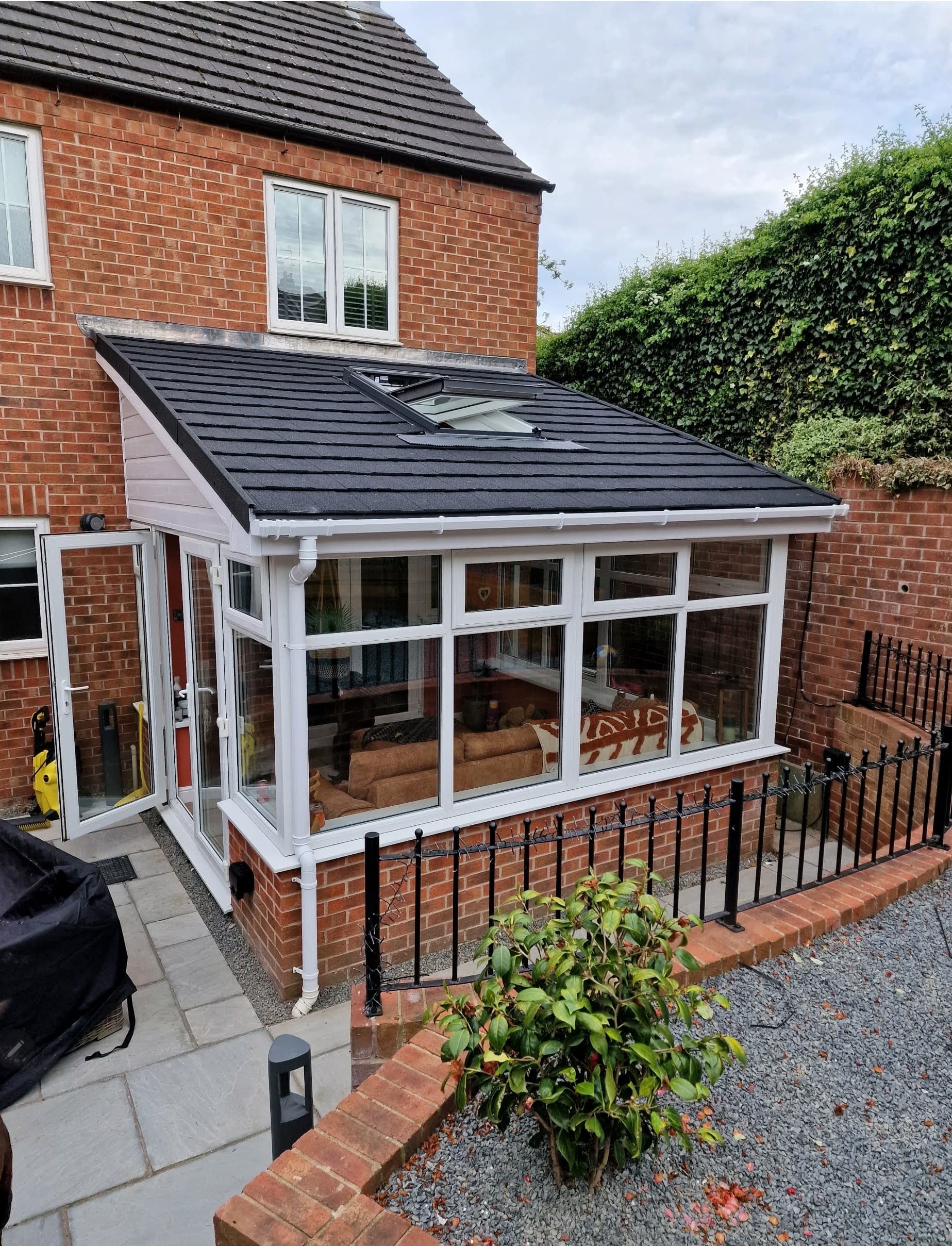 Lean-to conservatory with a new grey tiled warm roof and roof window