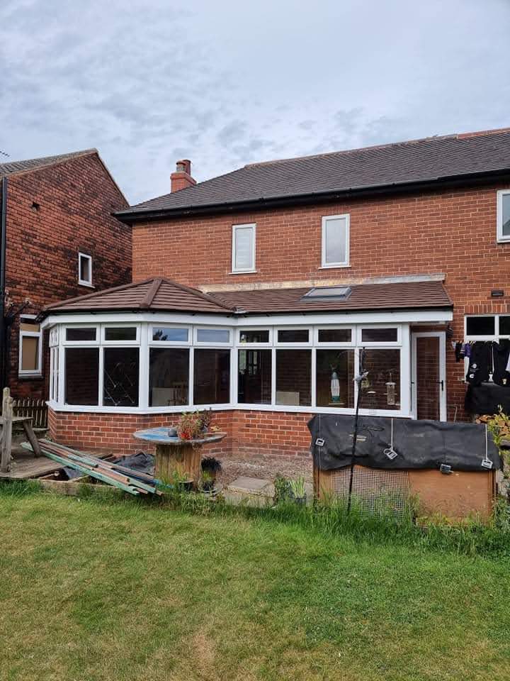 The finished tiled warm roof with a roof window letting in natural light