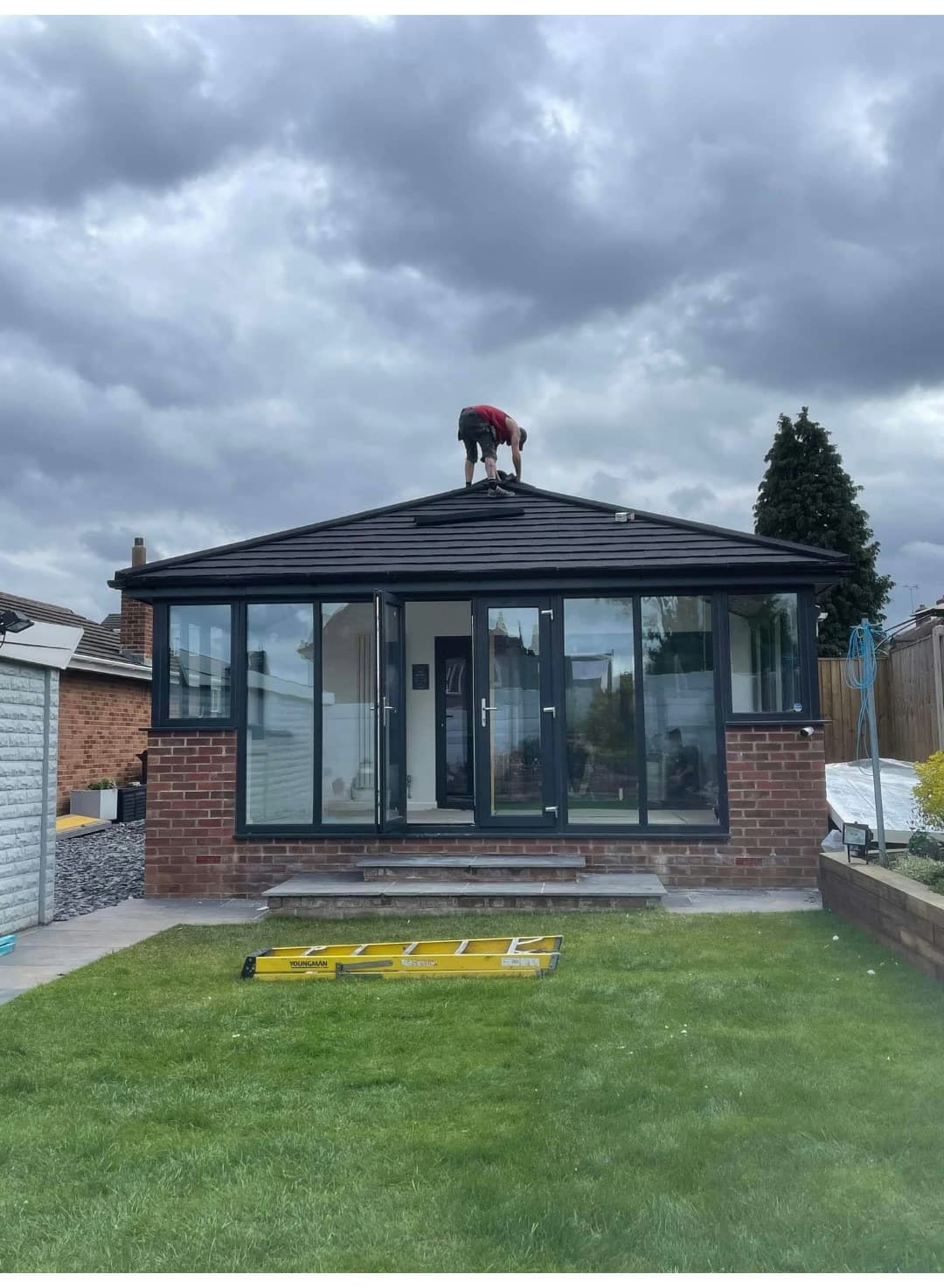 Roofer working on the finished anthracite tiled conservatory roof in Shirebrook