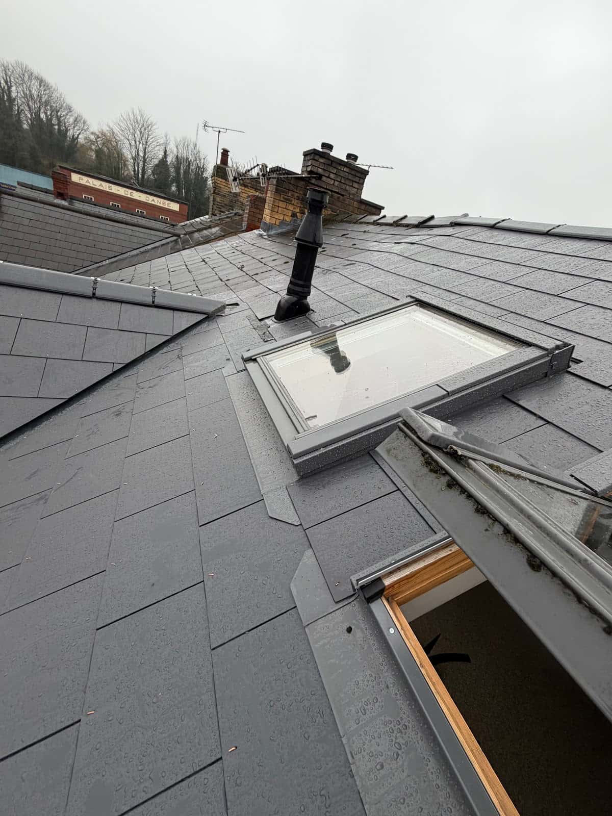 Grey slate roof with a new rooflight by WeatherTech Roofing