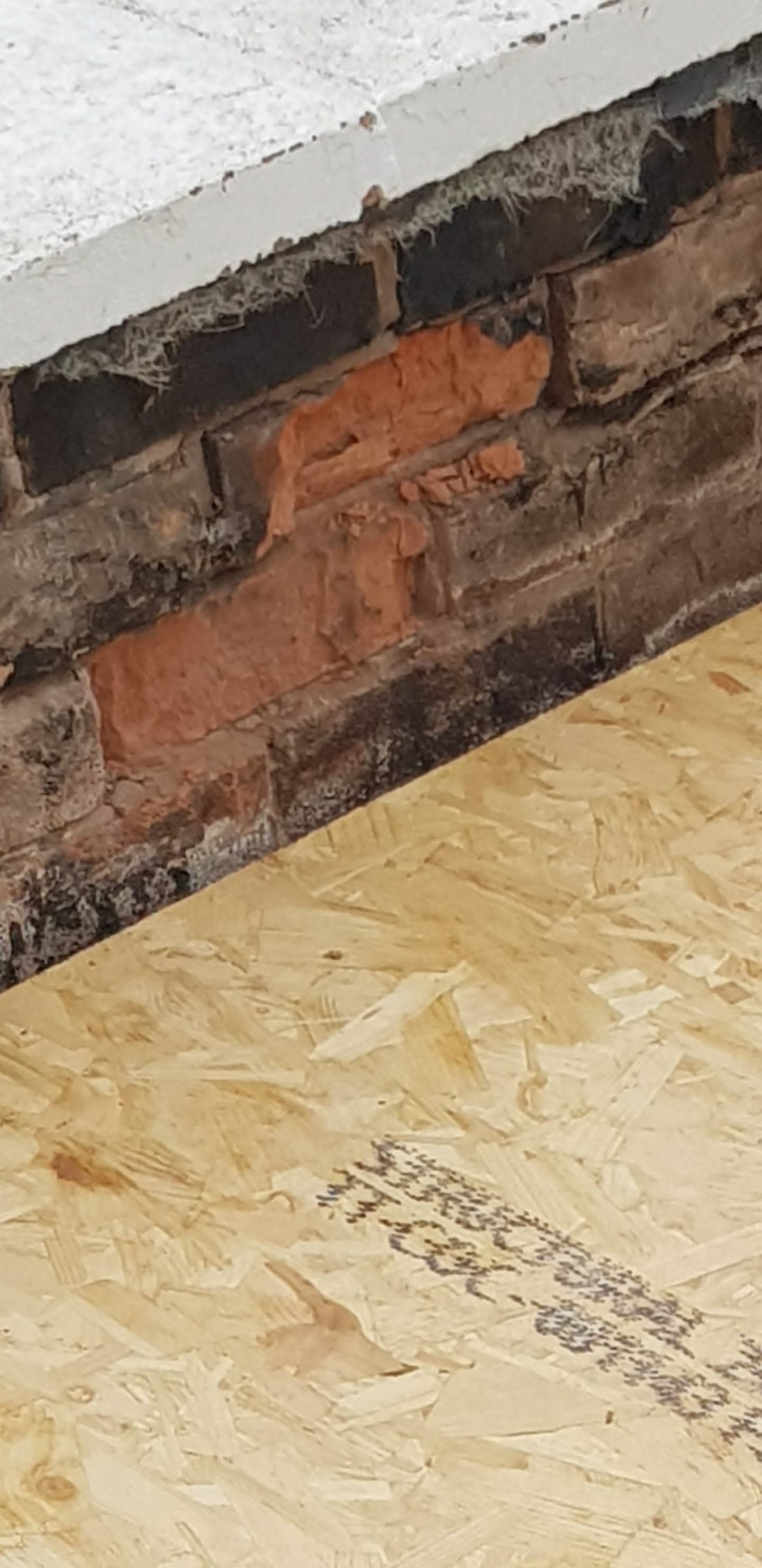 Exposed brick chimney stack with new OSB boarding during flat roof repair work