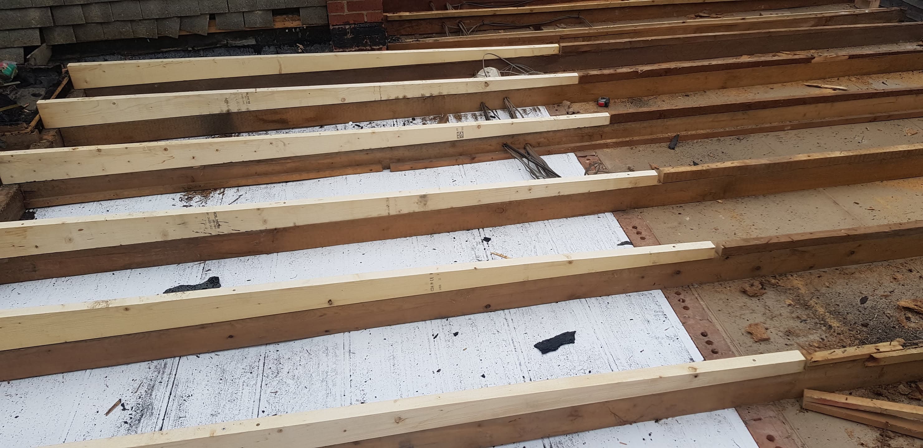 Flat roof with new timber battens installed over white membrane