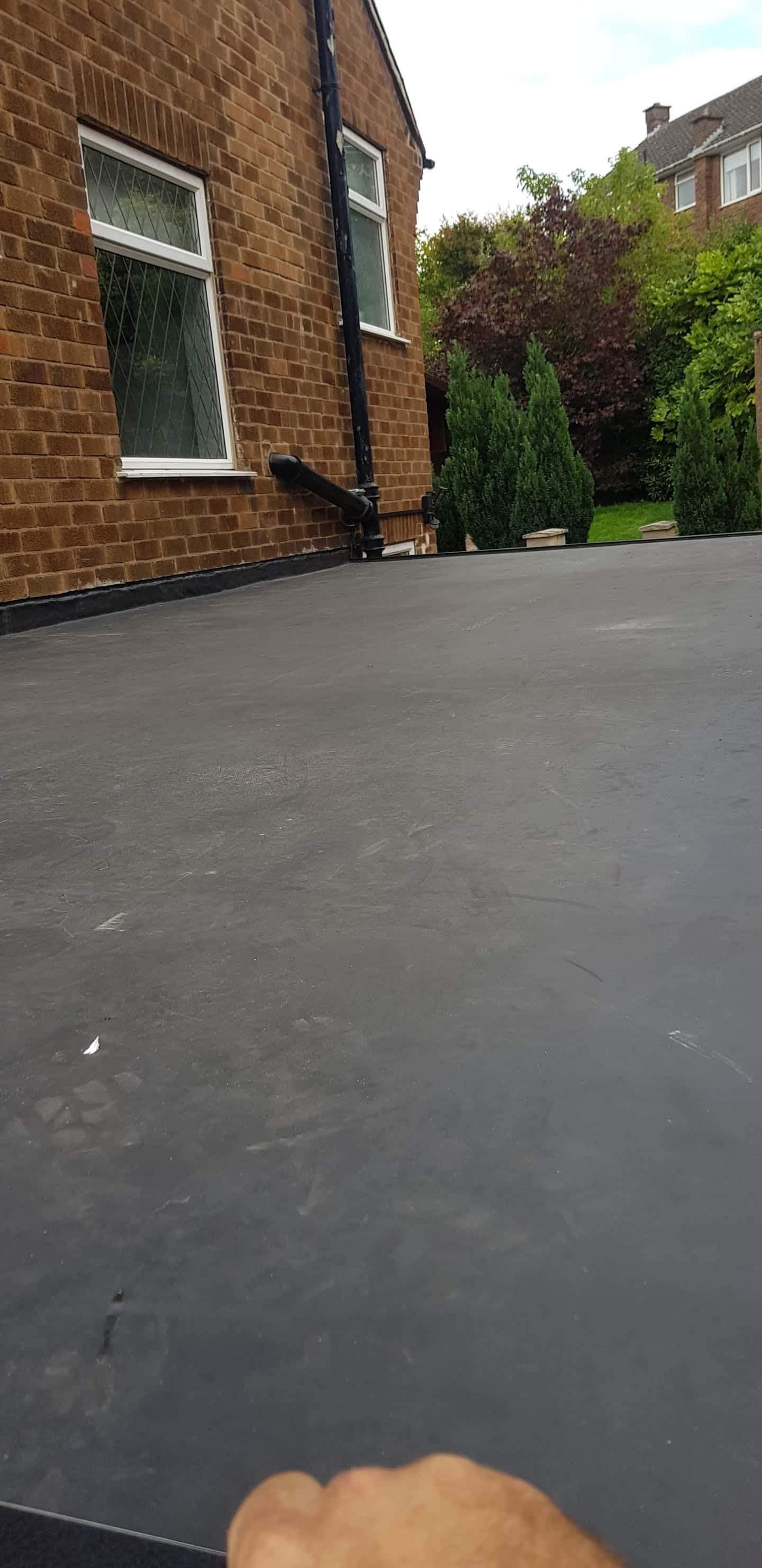 Completed grey EPDM rubber flat roof on residential extension