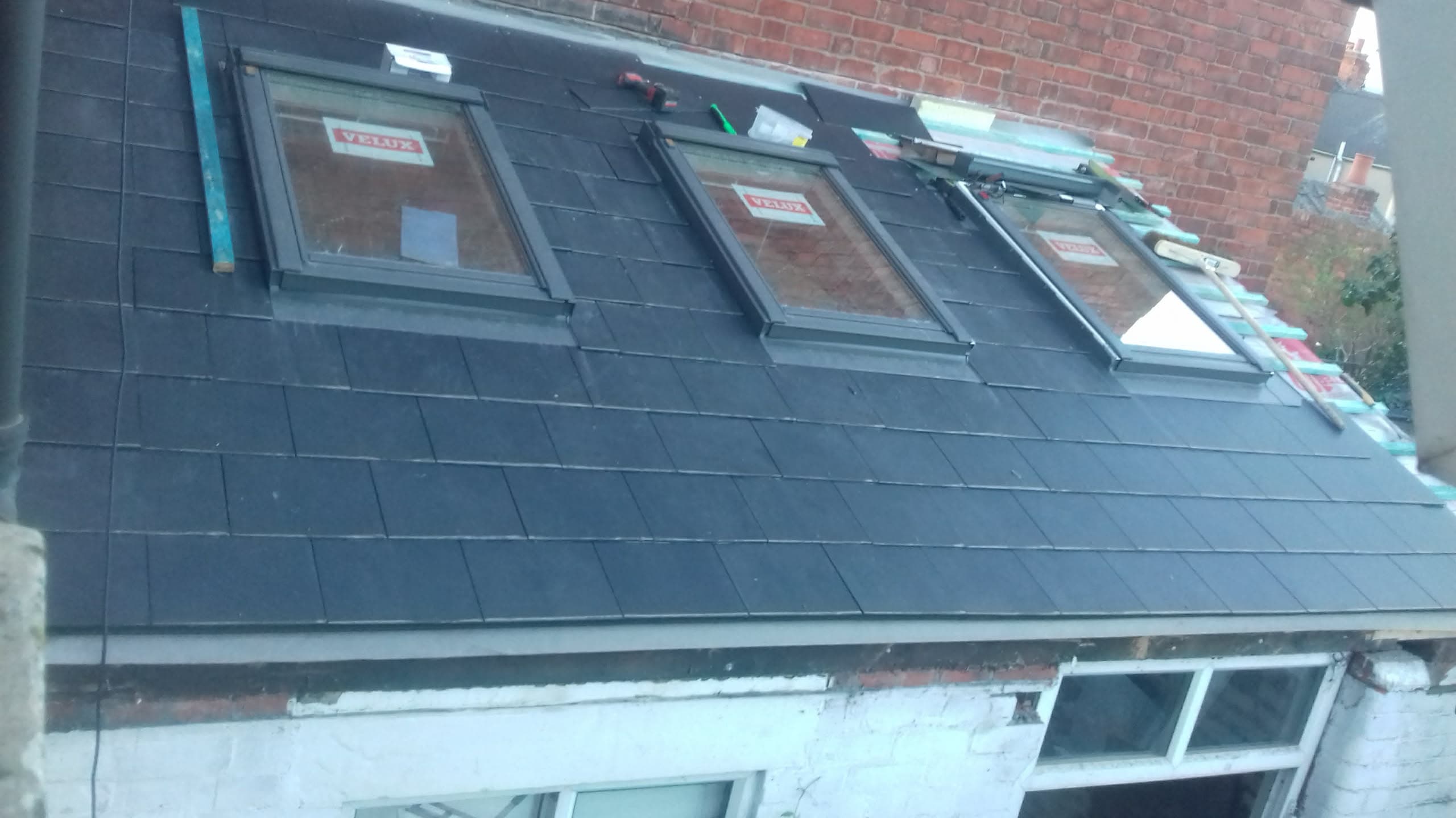Pitched slate roof with three Velux roof windows installed