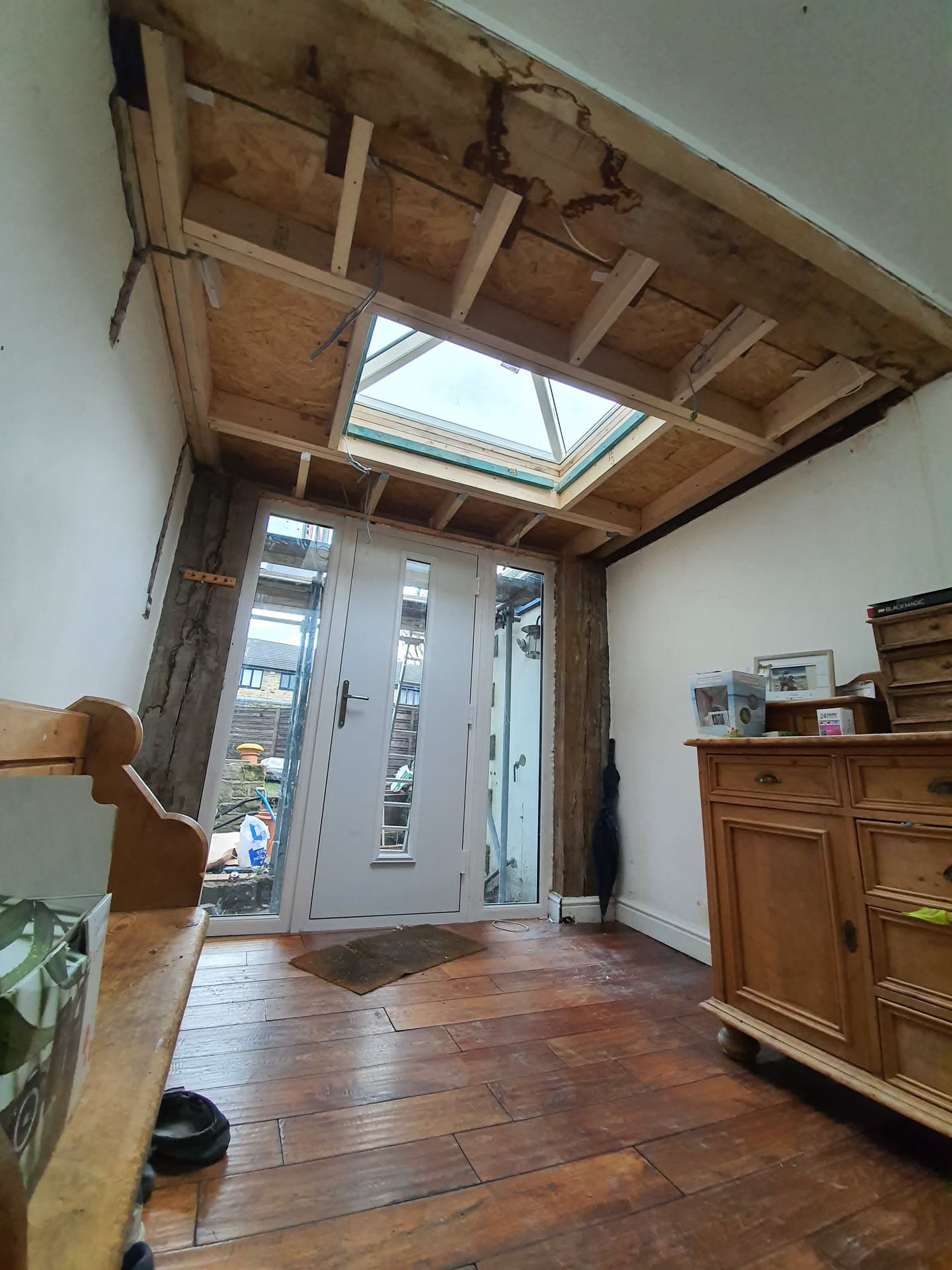 Interior view of flat roof installation with exposed timber joists and roof window