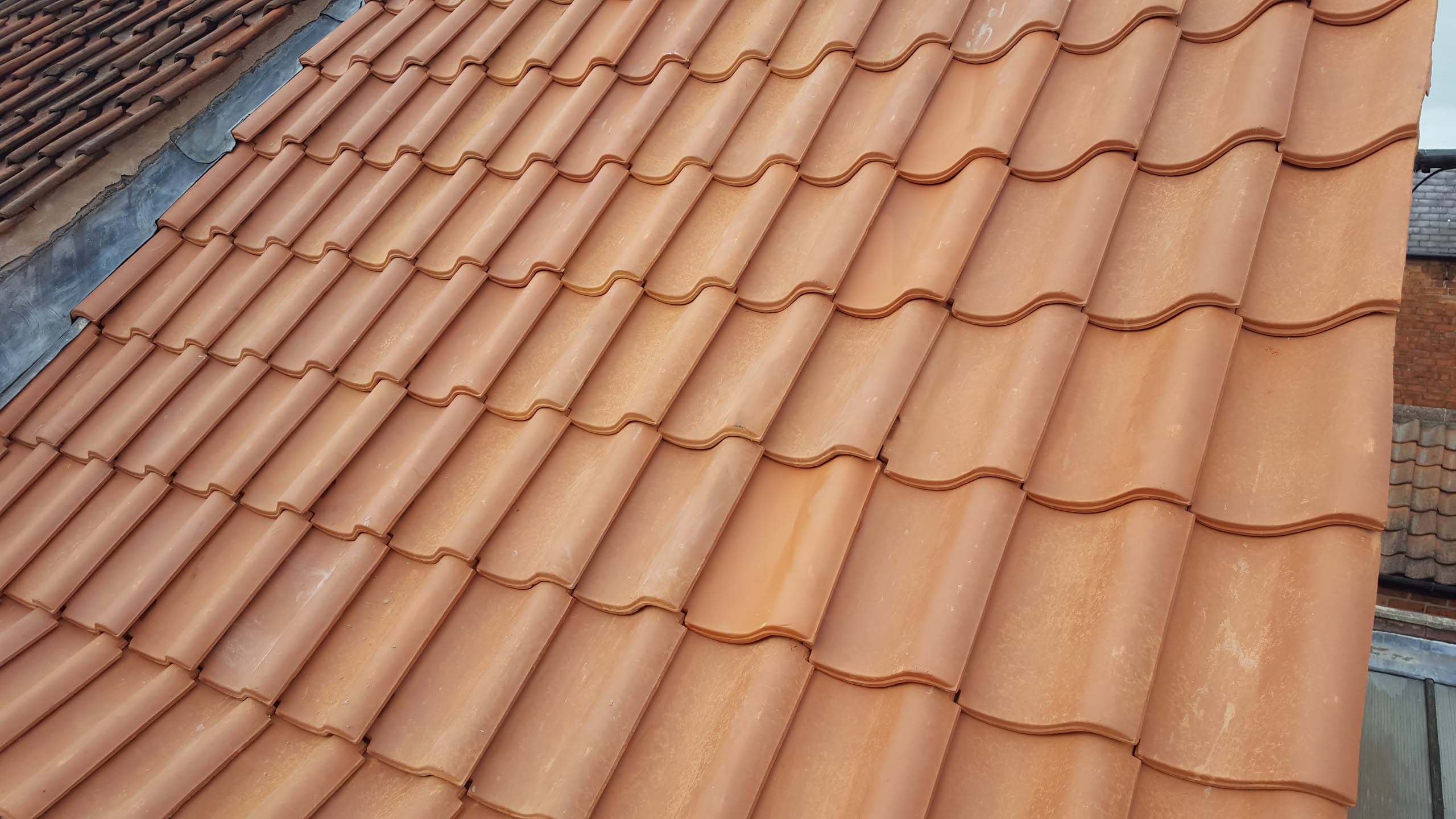 Pitched roof with terracotta clay tiles showing interlocking profile