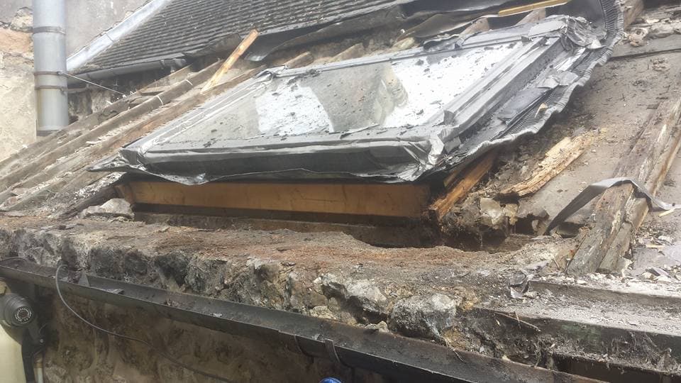 Damaged flat roof with deteriorated felt and exposed timber decking requiring replacement