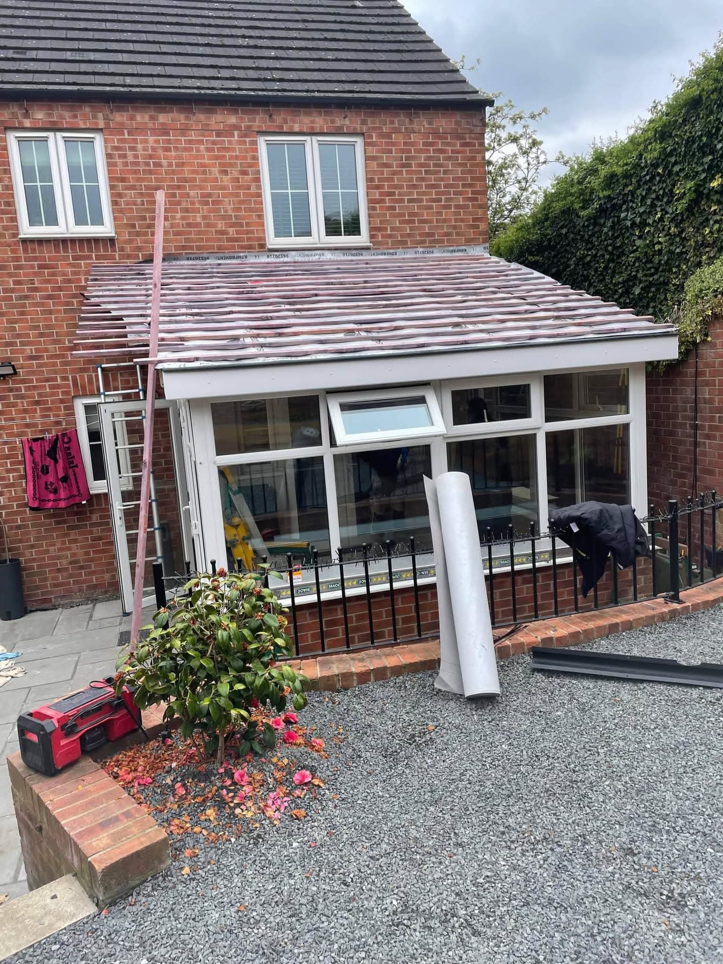 Conservatory roof replacement in progress with grey tiled roof and white fascias