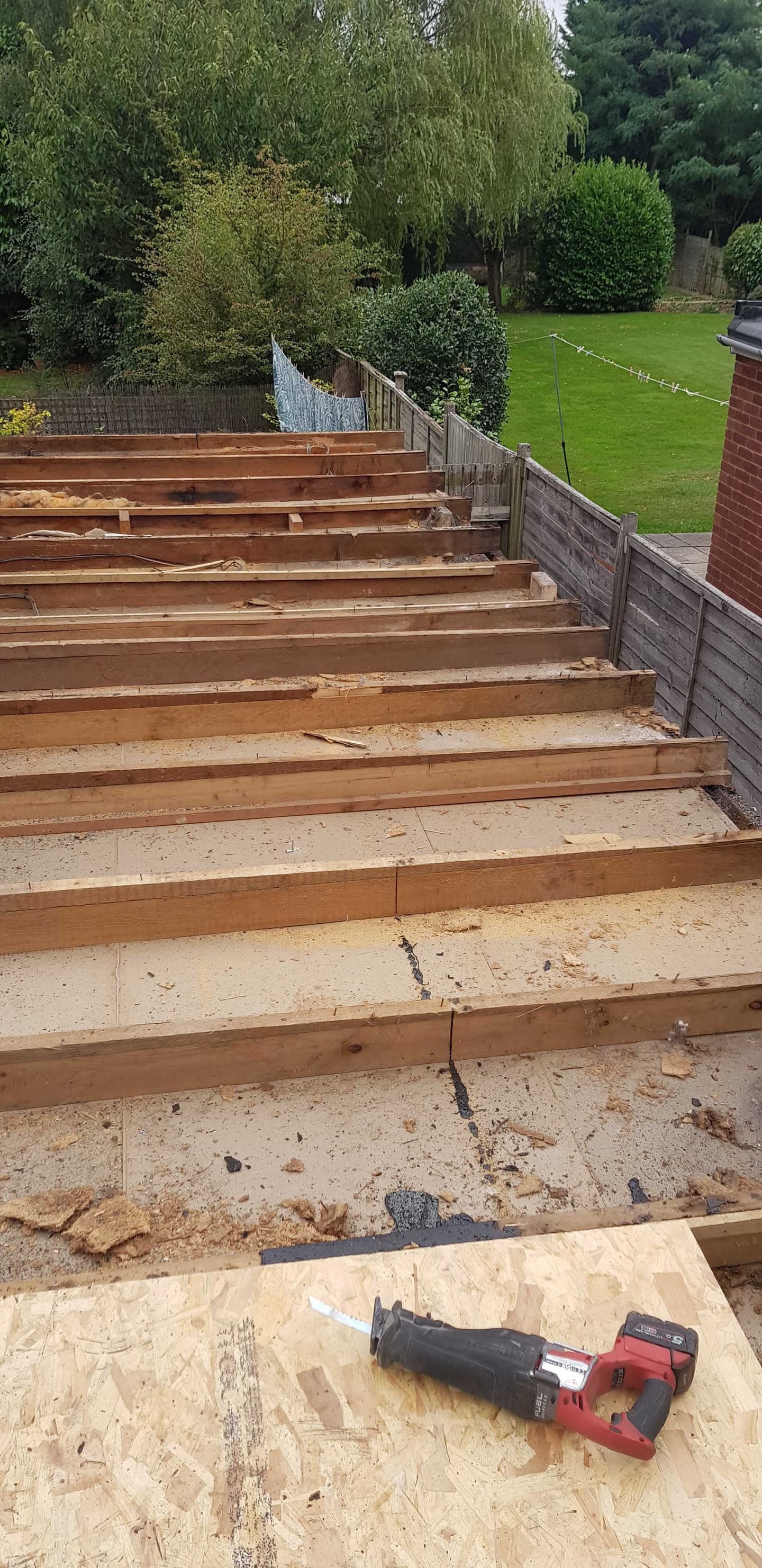 Flat roof timber framework and joists during construction with power tool visible