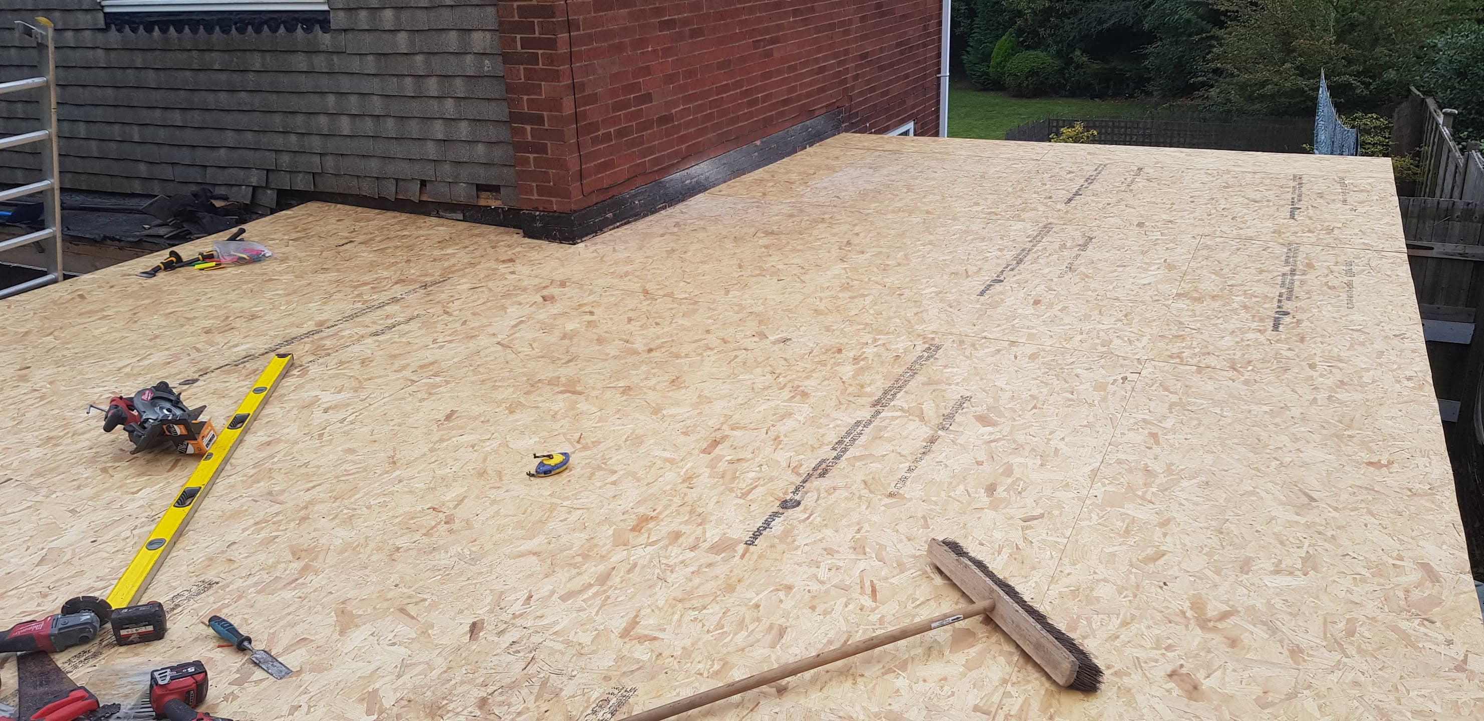 Flat roof with OSB decking boards and tools during installation