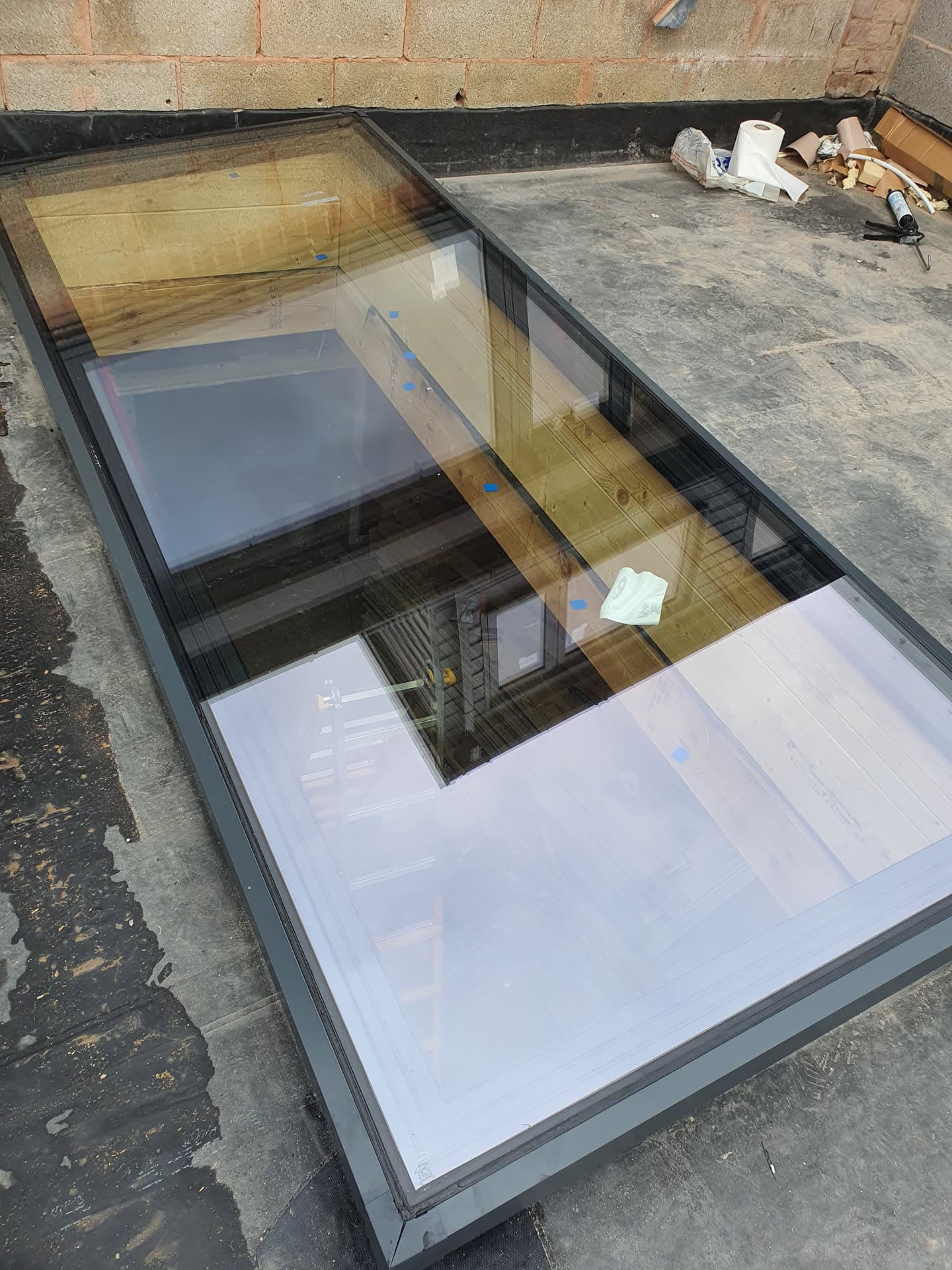 Flat roof with large glass rooflight panels and black felt surround