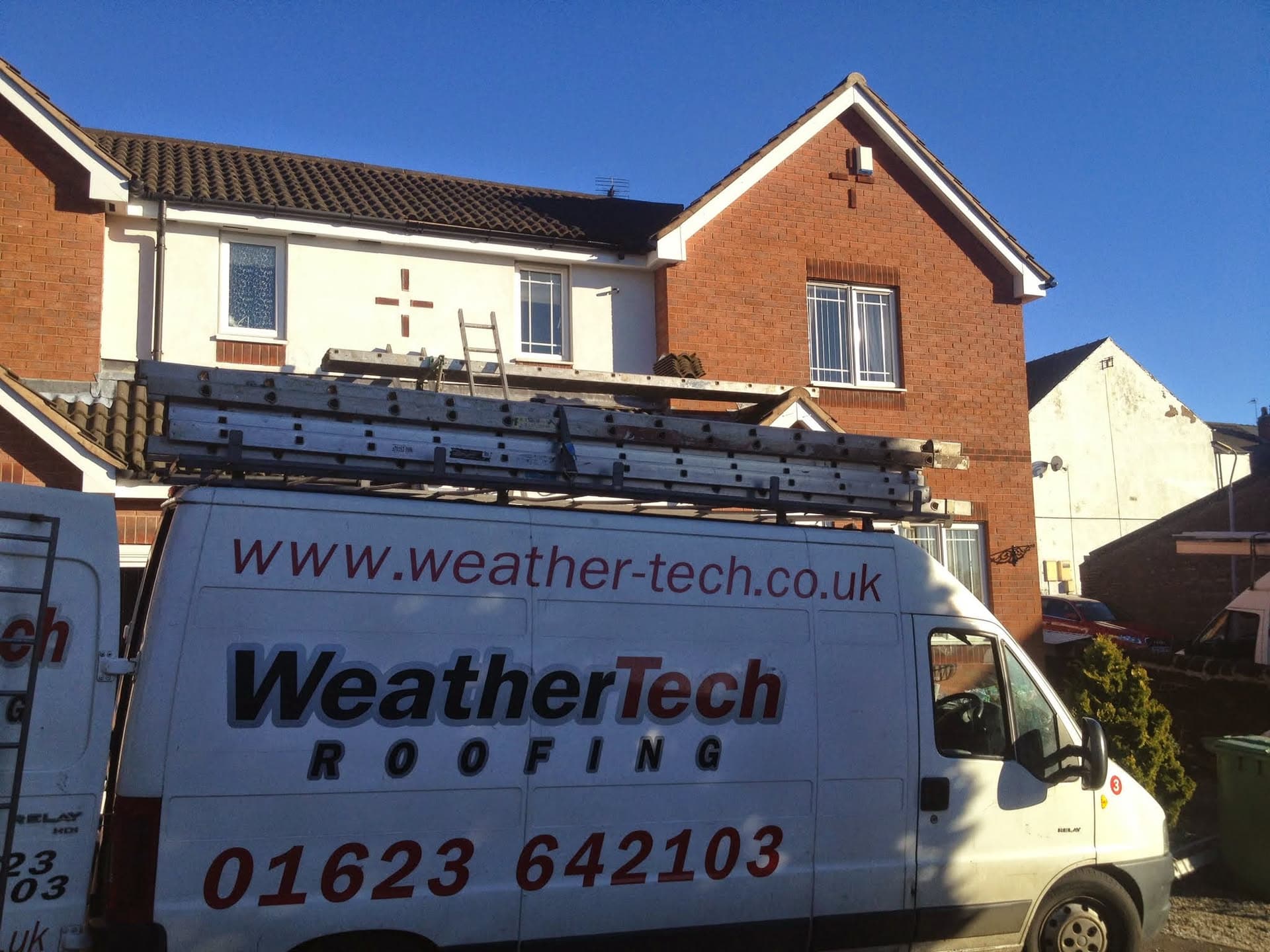 WeatherTech van parked outside residential property with dark concrete tiled pitched roof