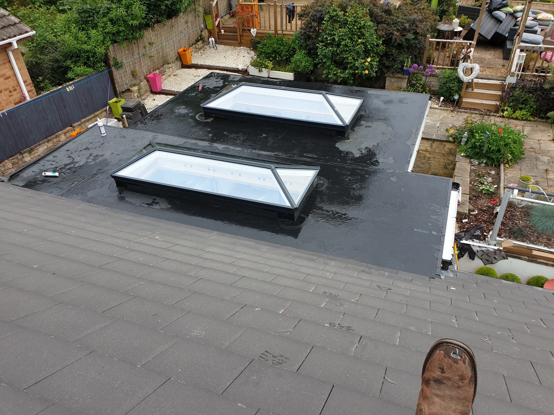 Flat roof with two glazed rooflights and dark grey felt covering