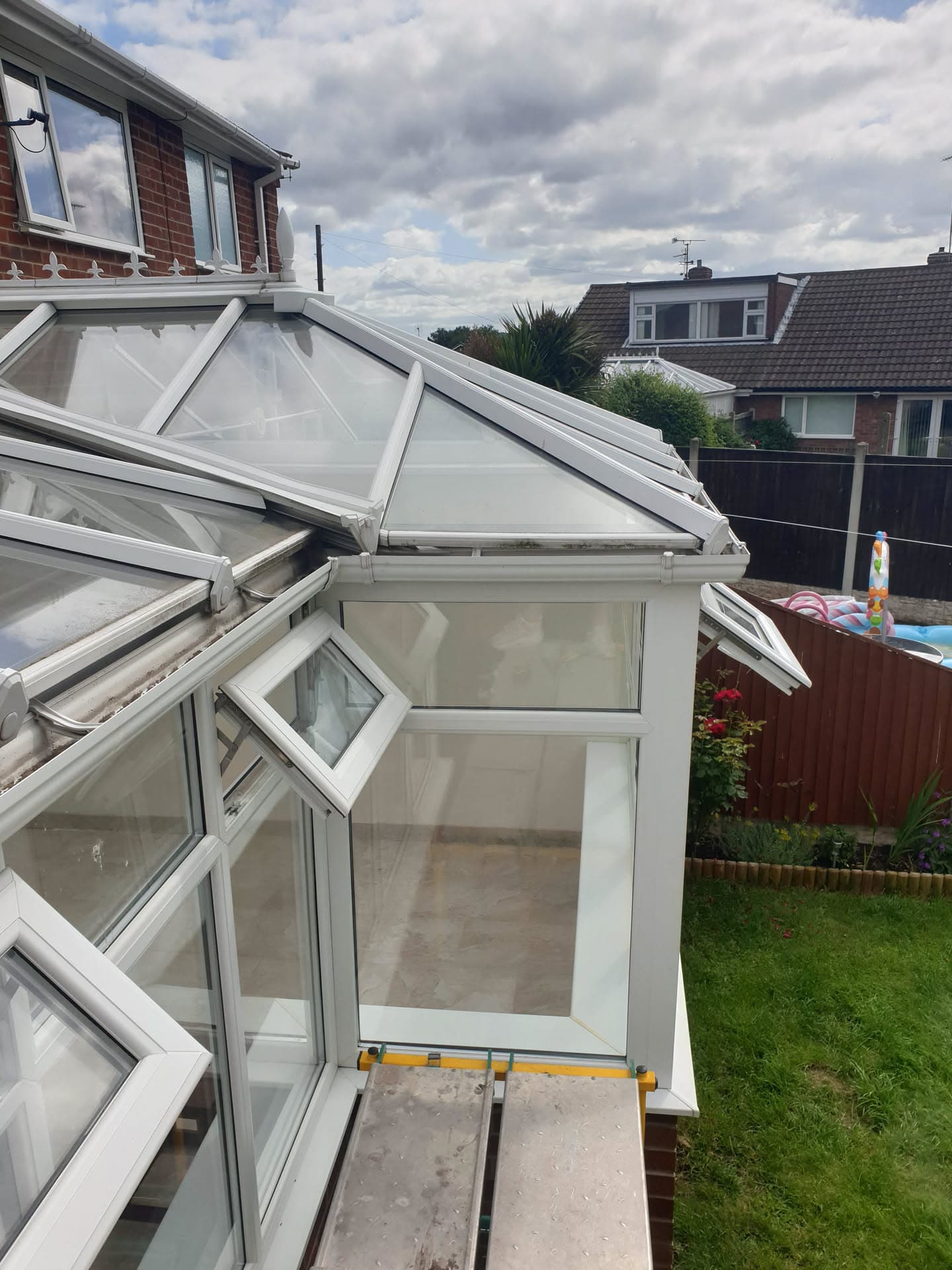 White uPVC conservatory with polycarbonate roof panels and open window vents