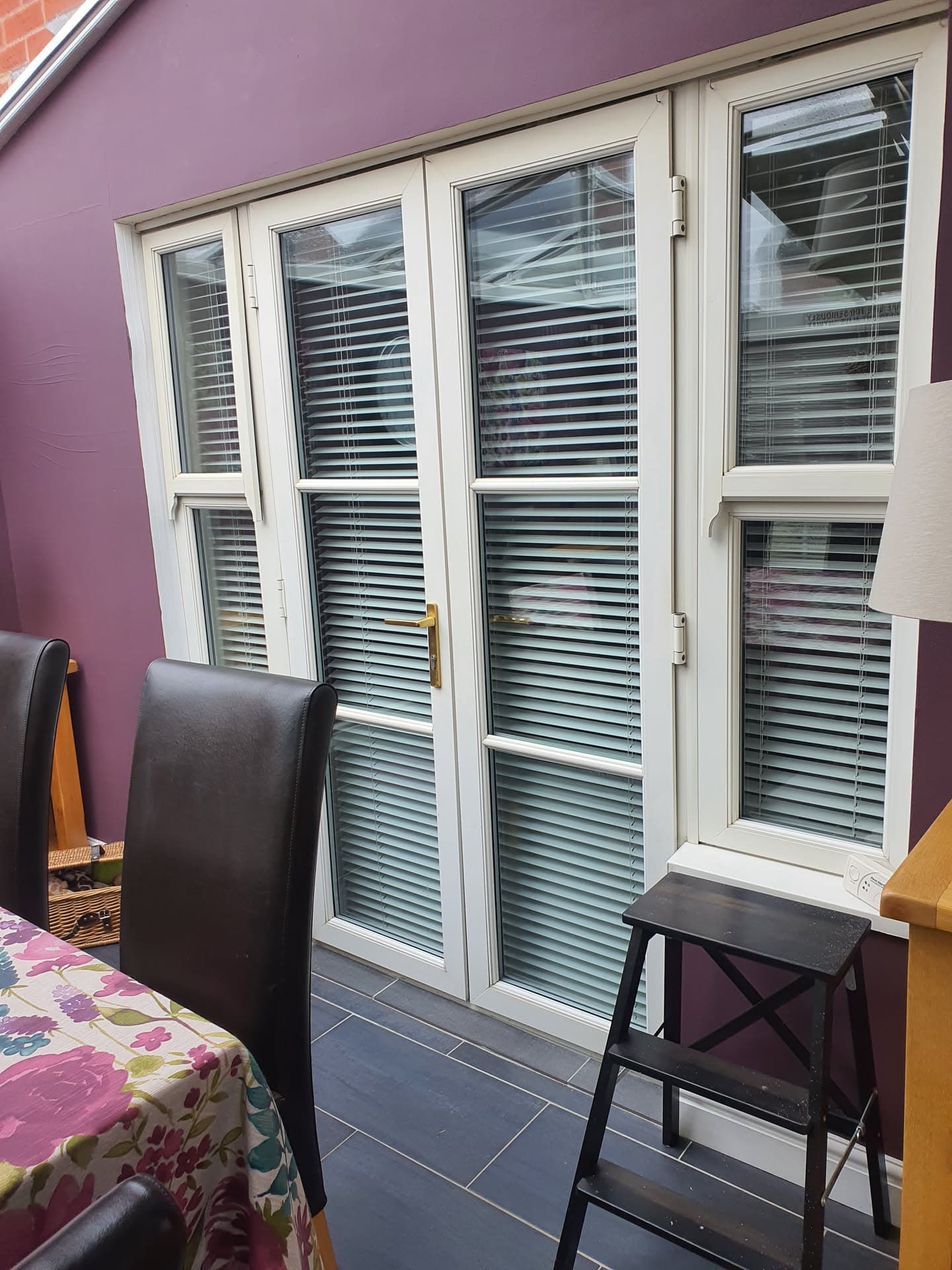 White uPVC French doors and windows with purple rendered walls
