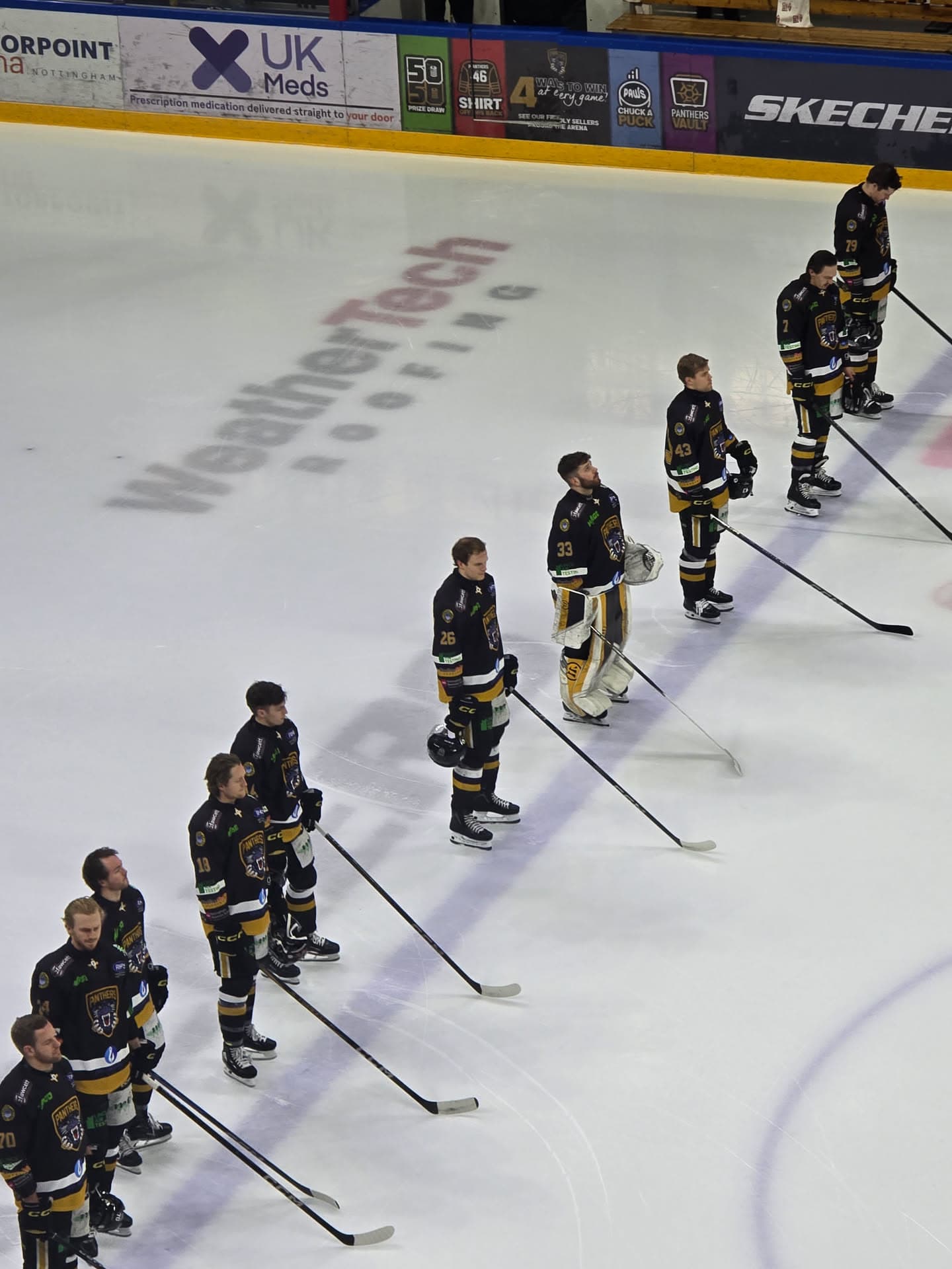 Nottingham Panthers squad gathered on the WeatherTech logo at the Motorpoint Arena
