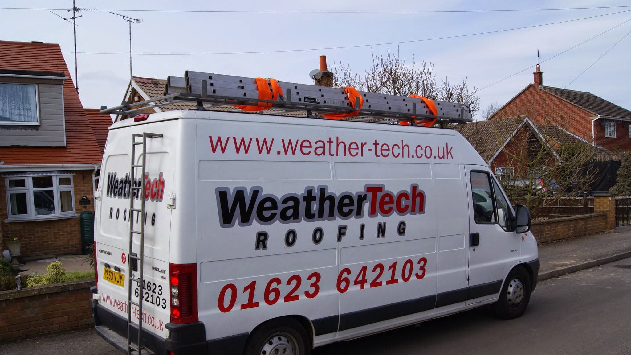 WeatherTech Roofing van with roof ladder and equipment parked on residential street