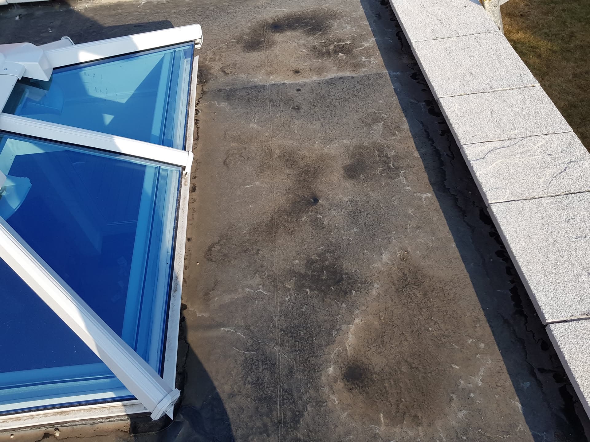 Flat roof with blue glass roof lantern and grey felt surface