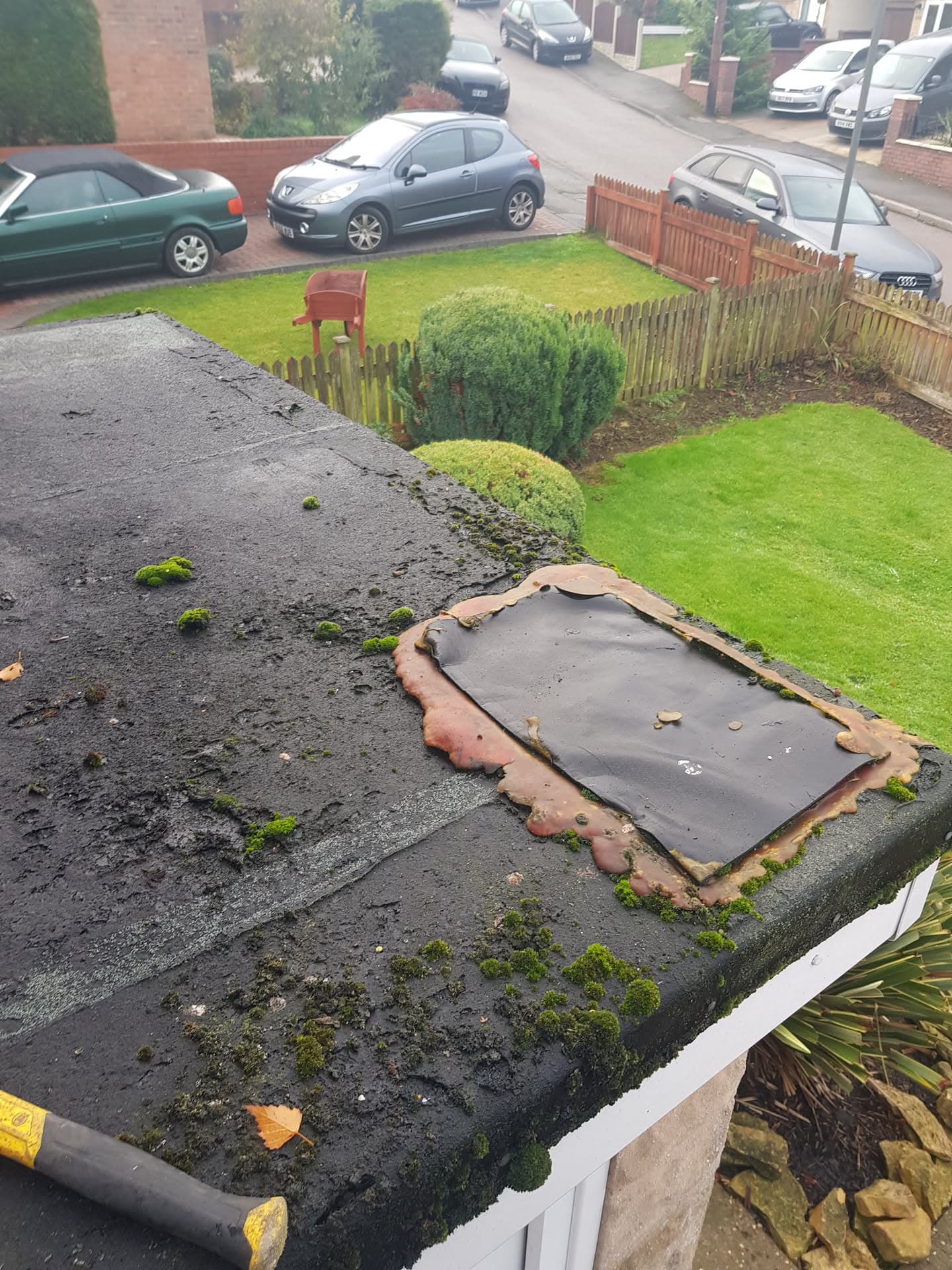 Damaged flat roof with deteriorating felt covering and moss growth