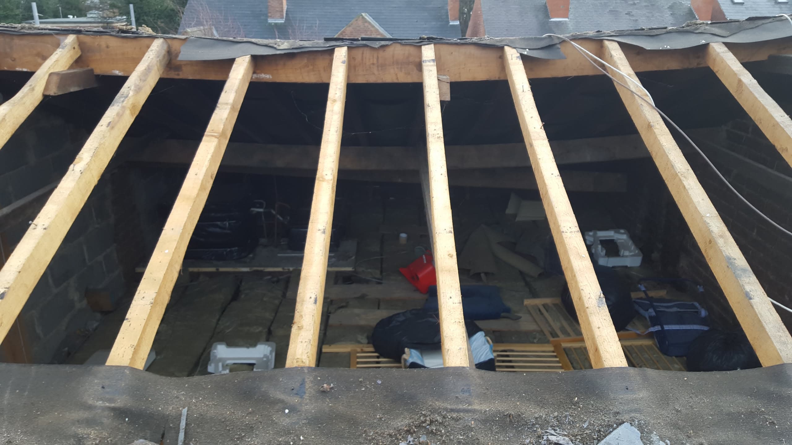 Flat roof installation in progress with timber battens and black felt membrane