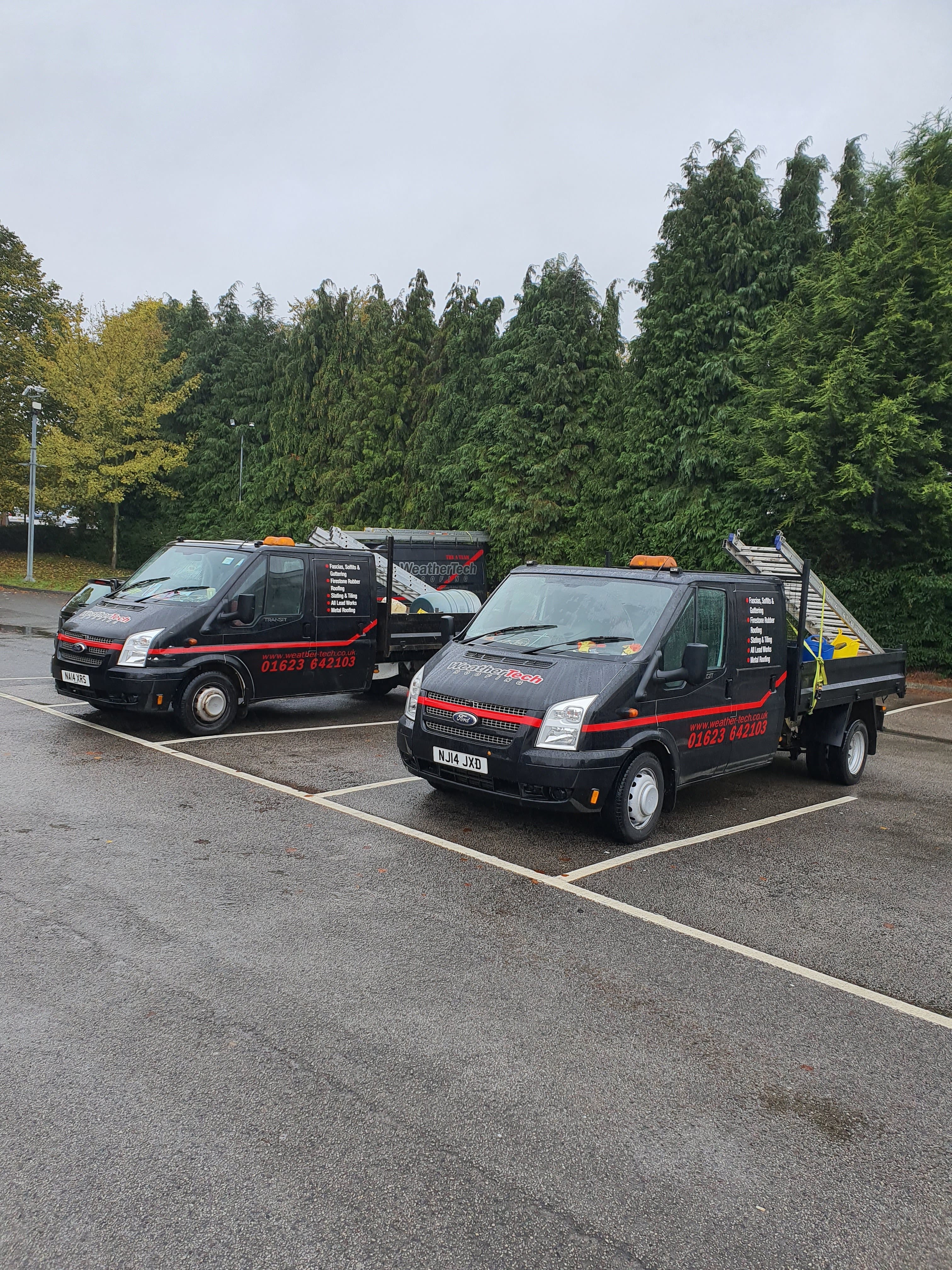 Two WeatherTech Roofing vans parked in a car park carrying roofing materials and ladders