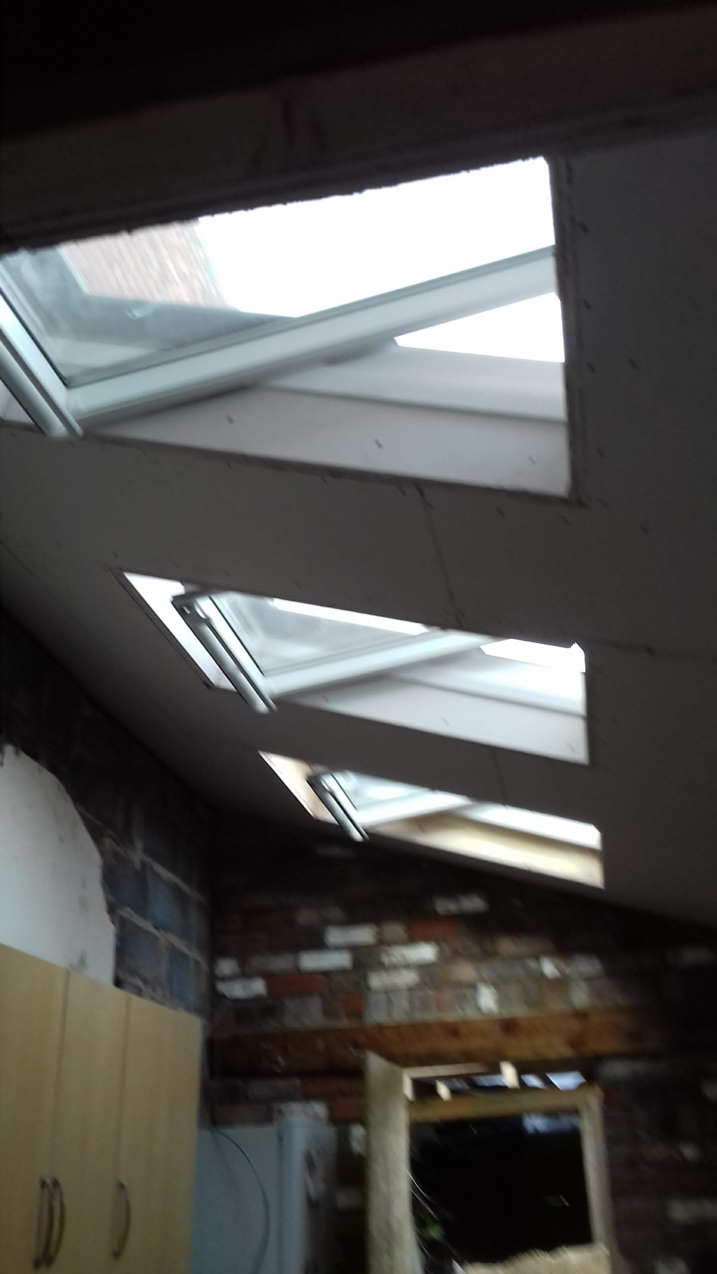 Interior view of three roof windows installed in a pitched roof with white frames
