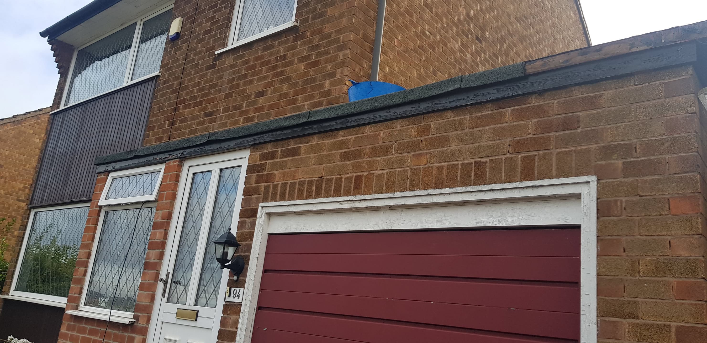 Pitched roof with dark grey tiles on brick terraced house