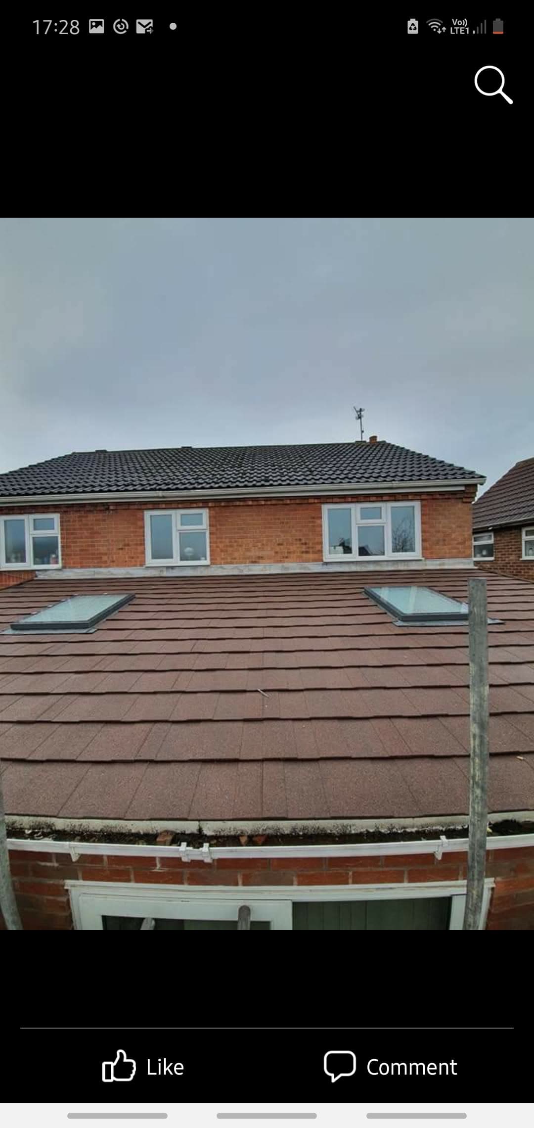 Brown concrete tiled pitched roof with two skylights and white fascias and guttering