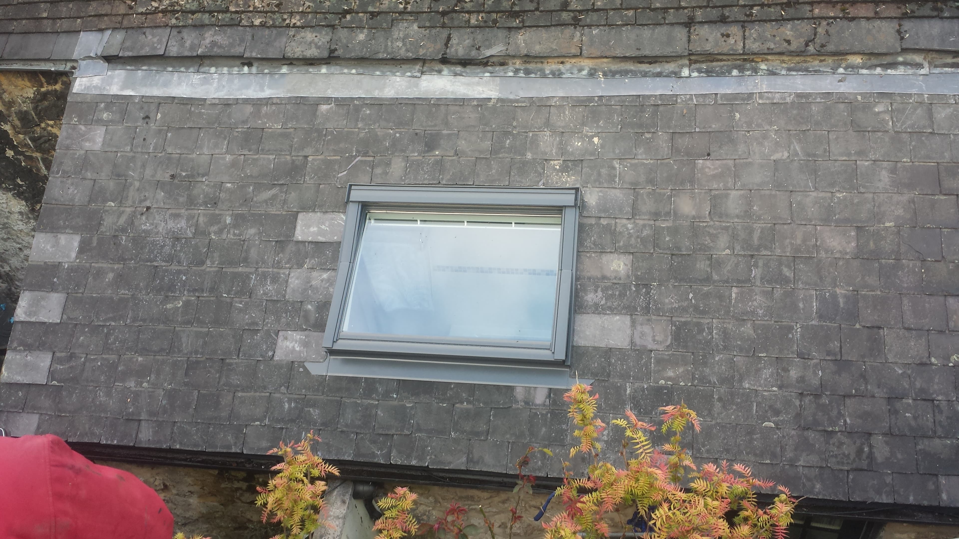 Pitched slate roof with lead flashing around roof window