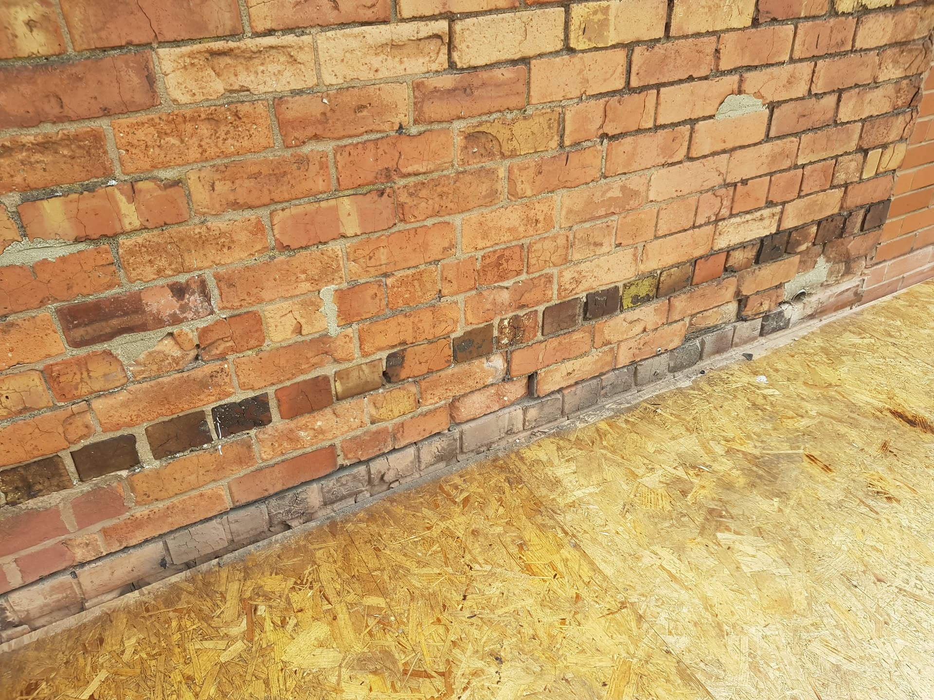 OSB boarding installed on flat roof against brick wall