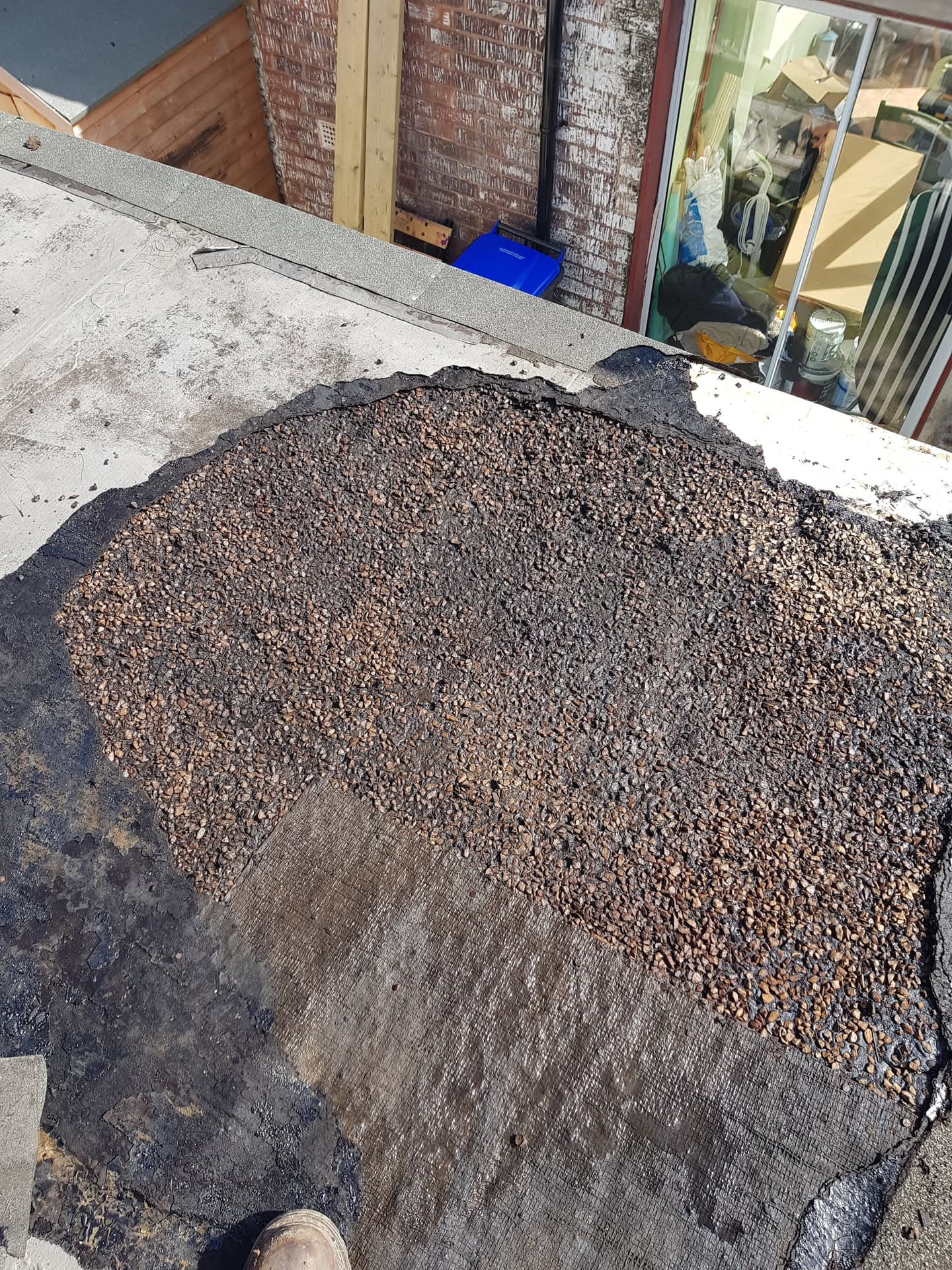 Flat roof with stone chippings and felt membrane during repair work