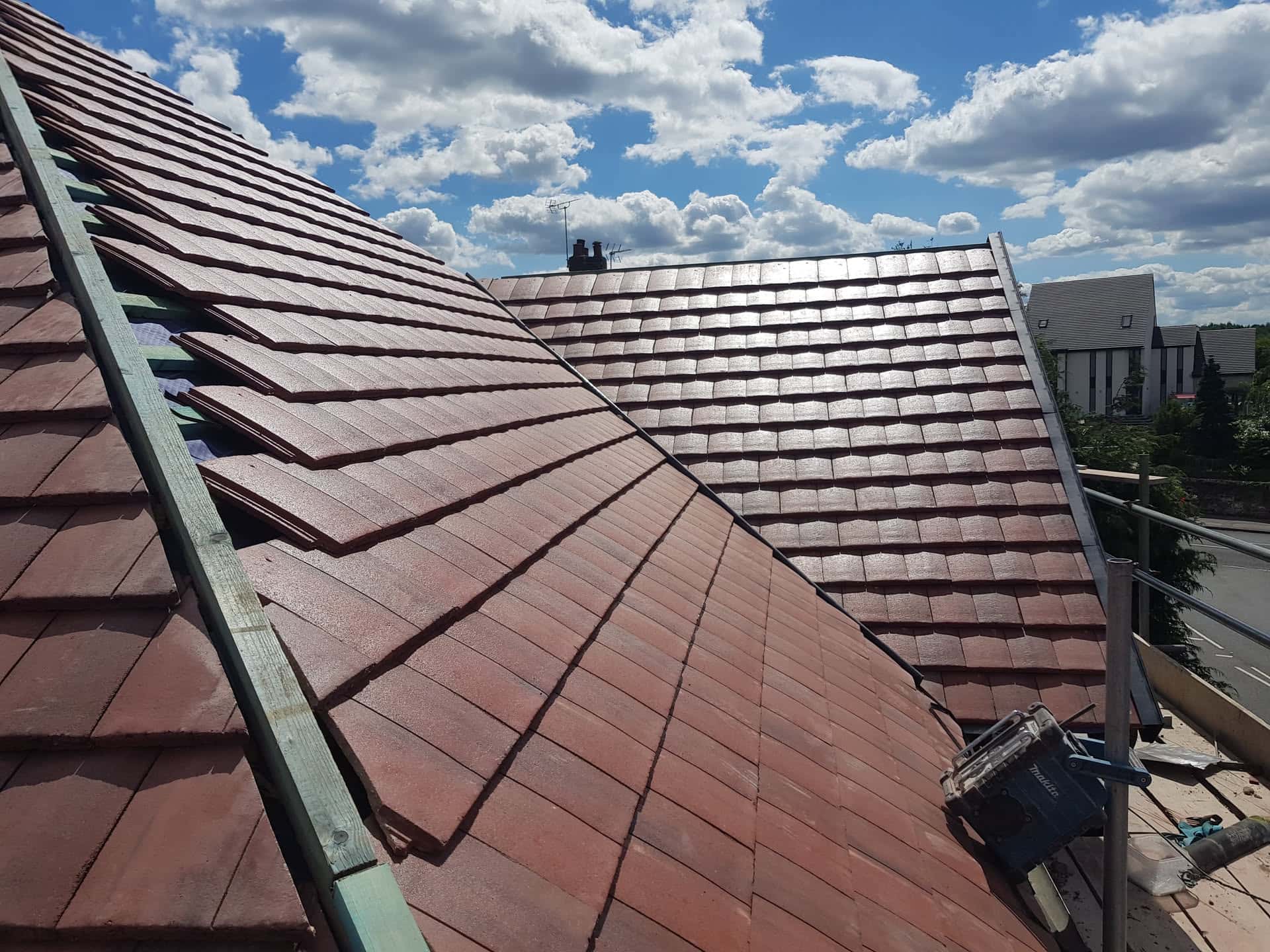 Newly completed pitched roof with red concrete tiles and ridge line