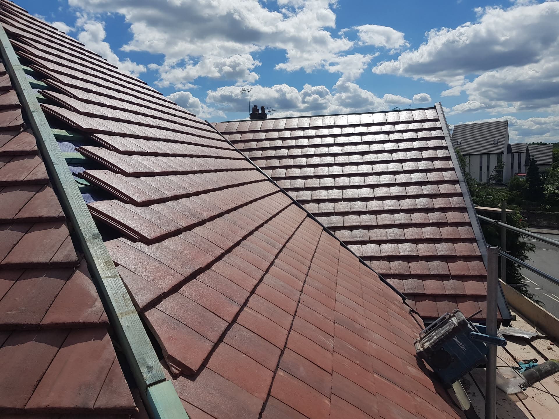 Newly completed pitched roof with red concrete tiles and ridge line