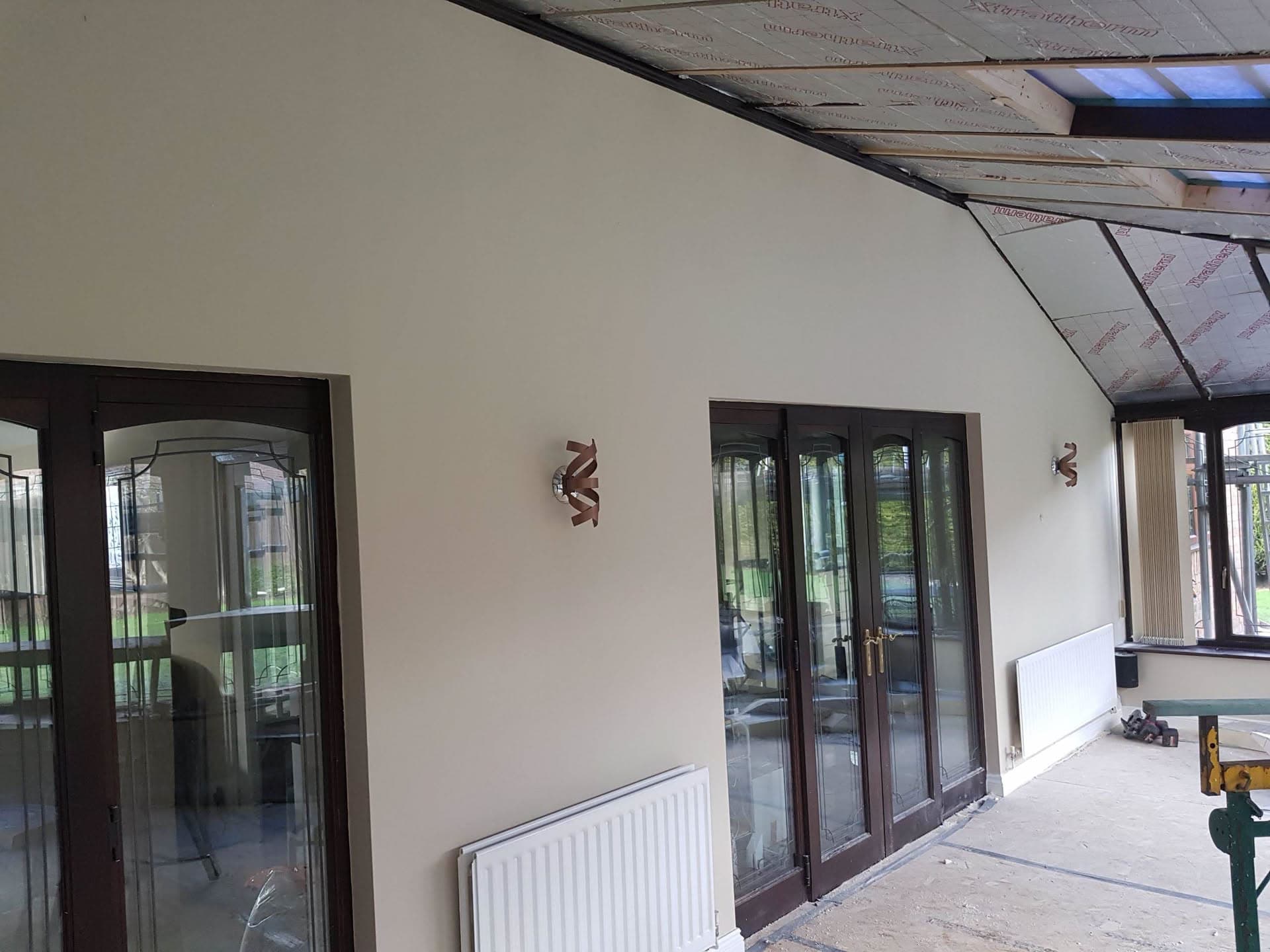Interior view of conservatory with exposed roof insulation boards between rafters during construction