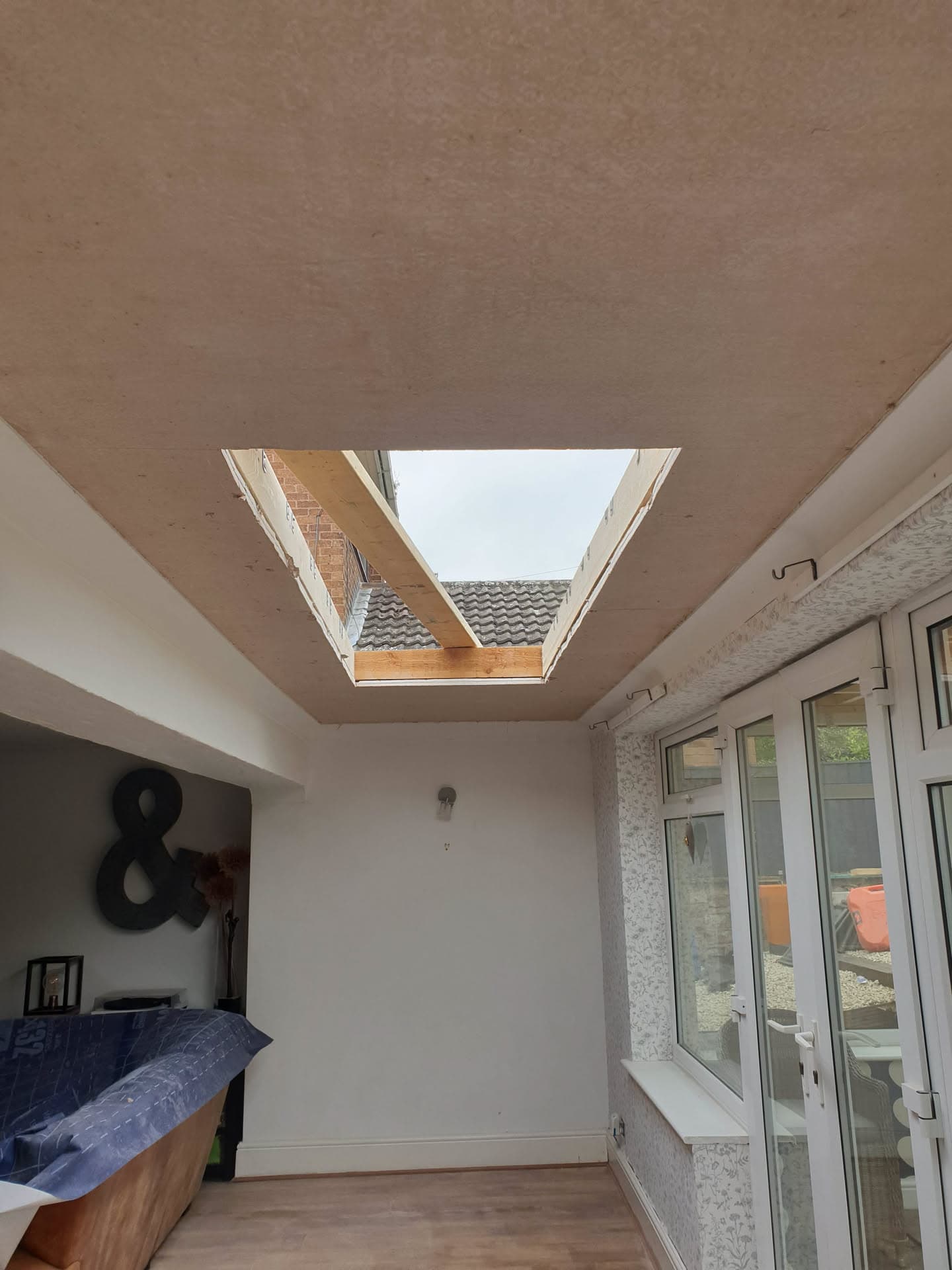 Interior view of conservatory with plastered ceiling and roof window showing tiled roof outside