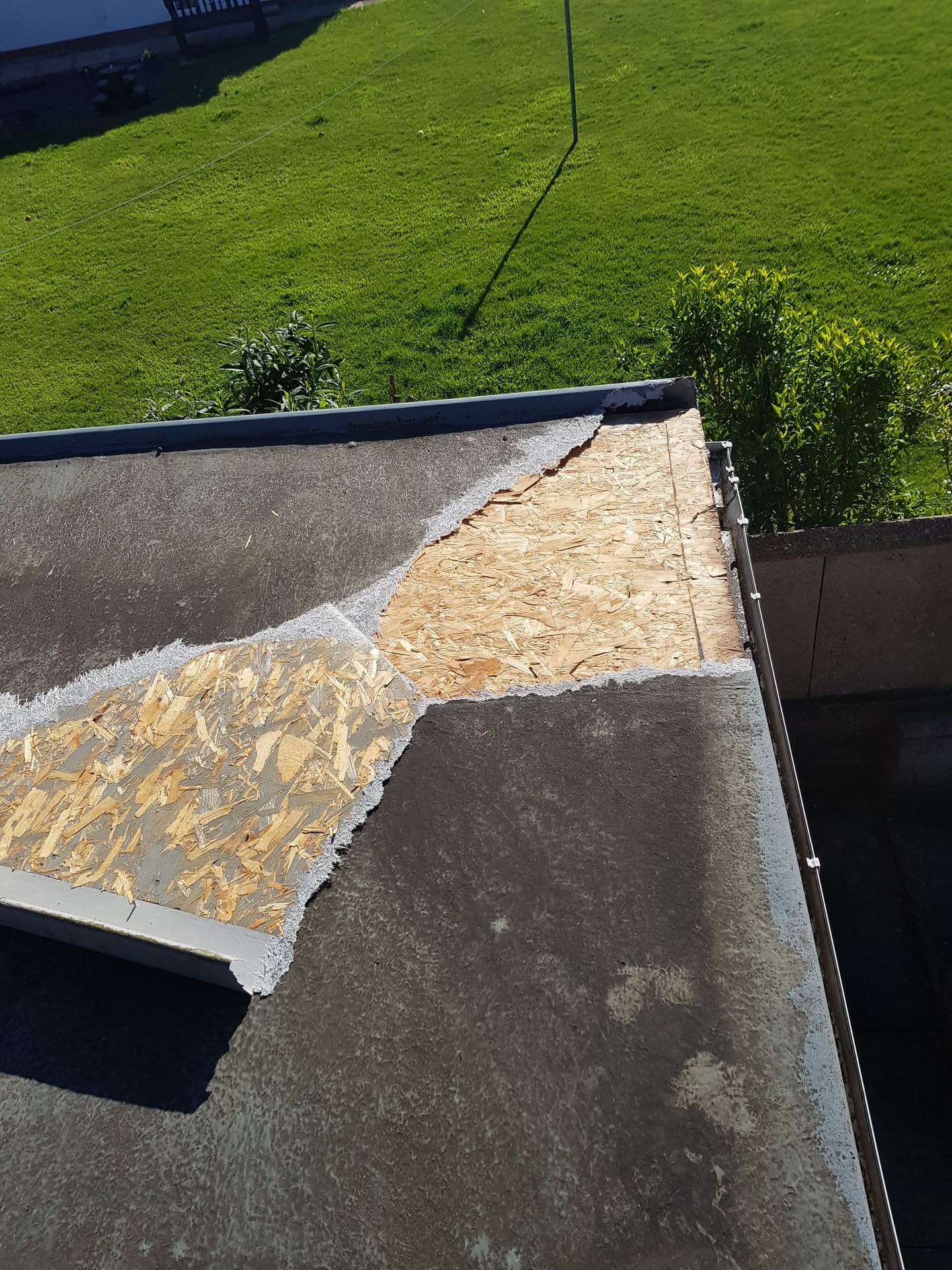 Flat roof with exposed OSB board during felt replacement work