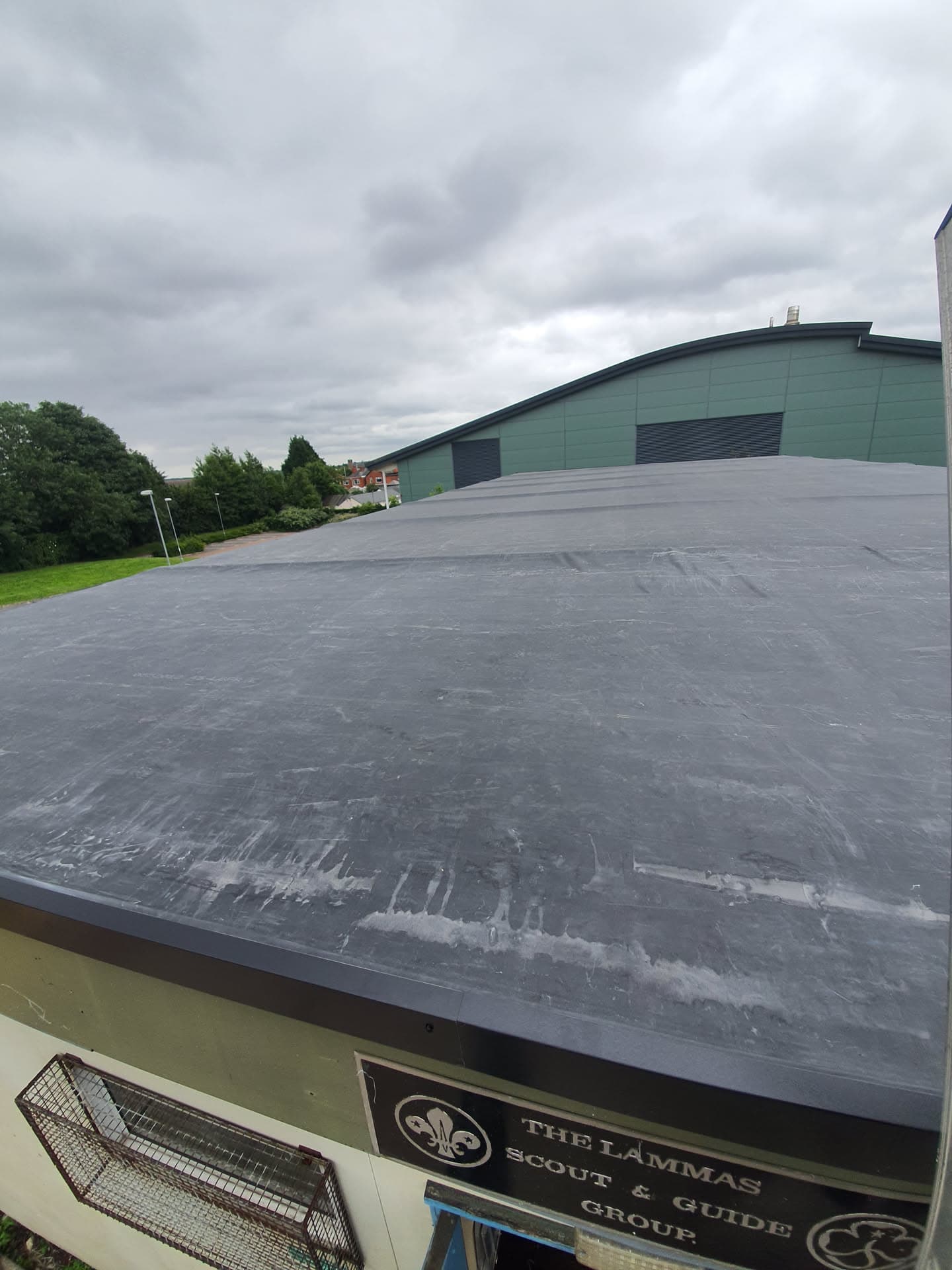Completed flat roof installation with grey EPDM rubber membrane on commercial building