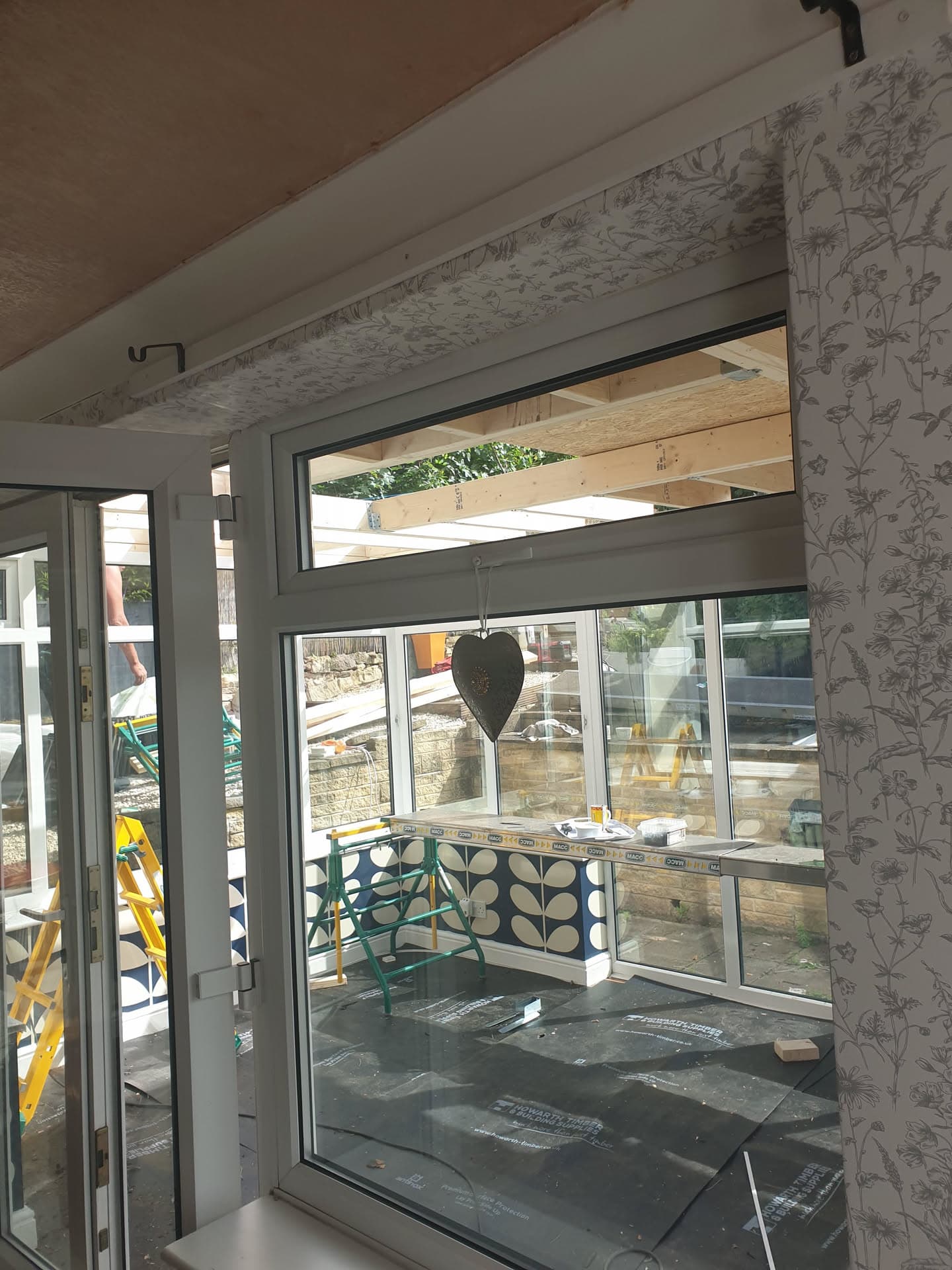 Interior view of conservatory with white uPVC frame and timber roof structure under construction