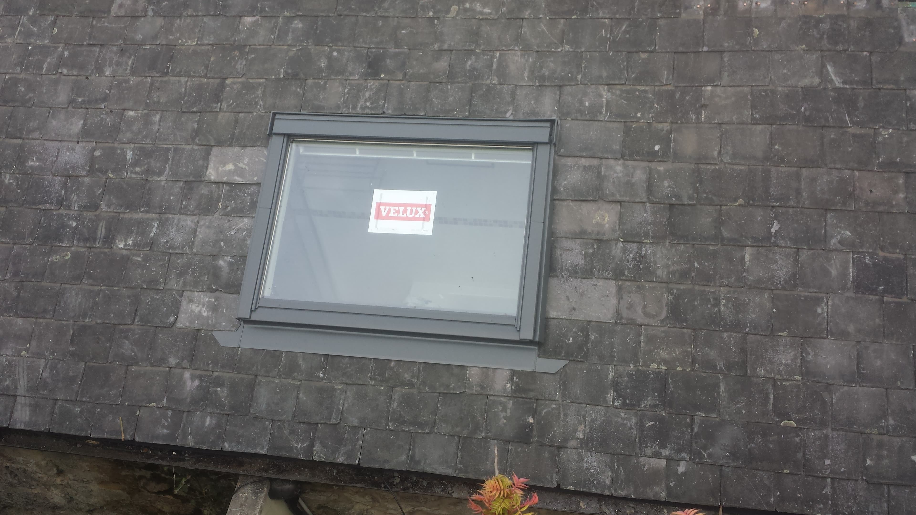 Velux roof window installed on dark slate pitched roof