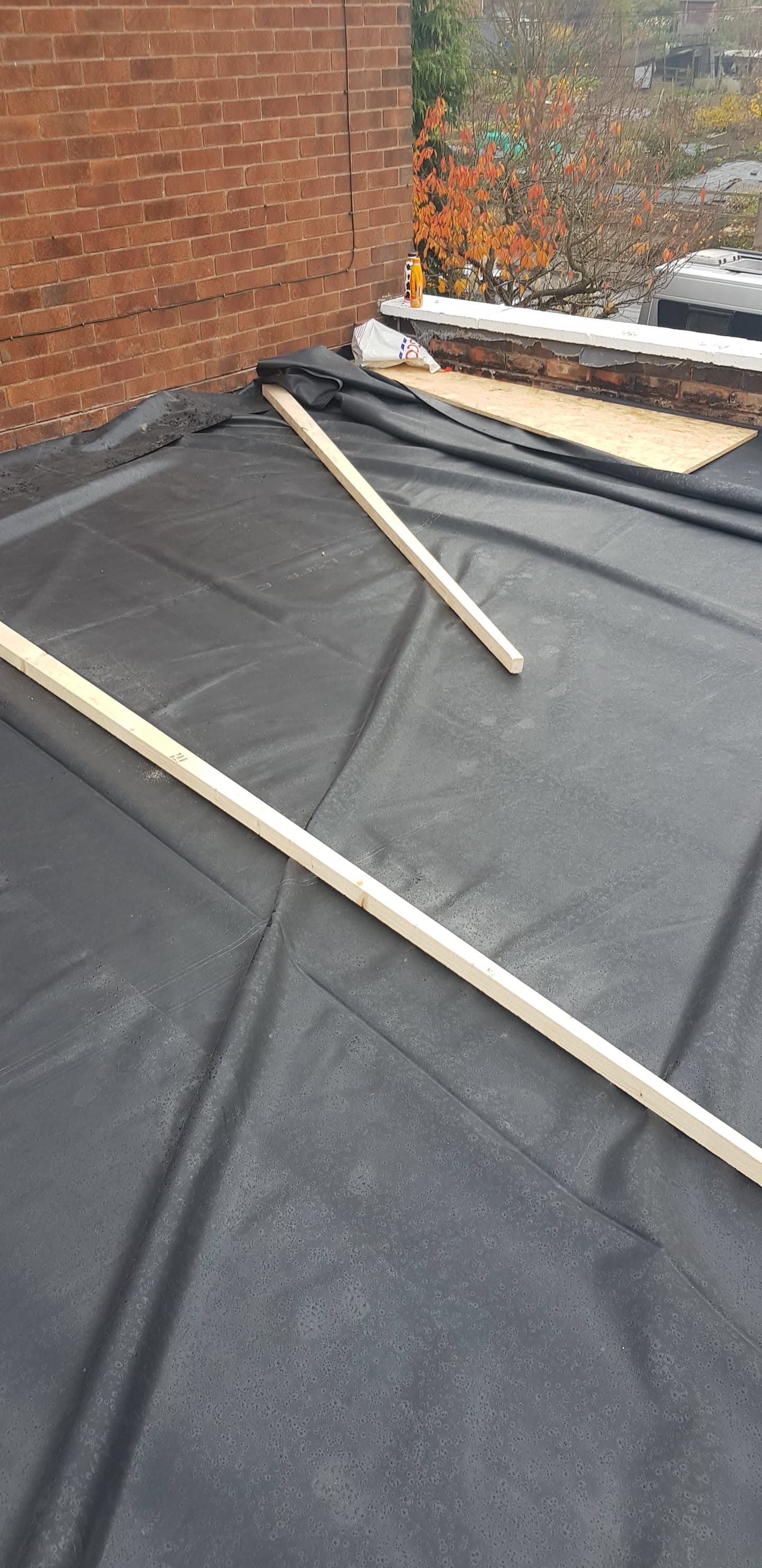 Flat roof with black EPDM rubber membrane and timber battens during installation