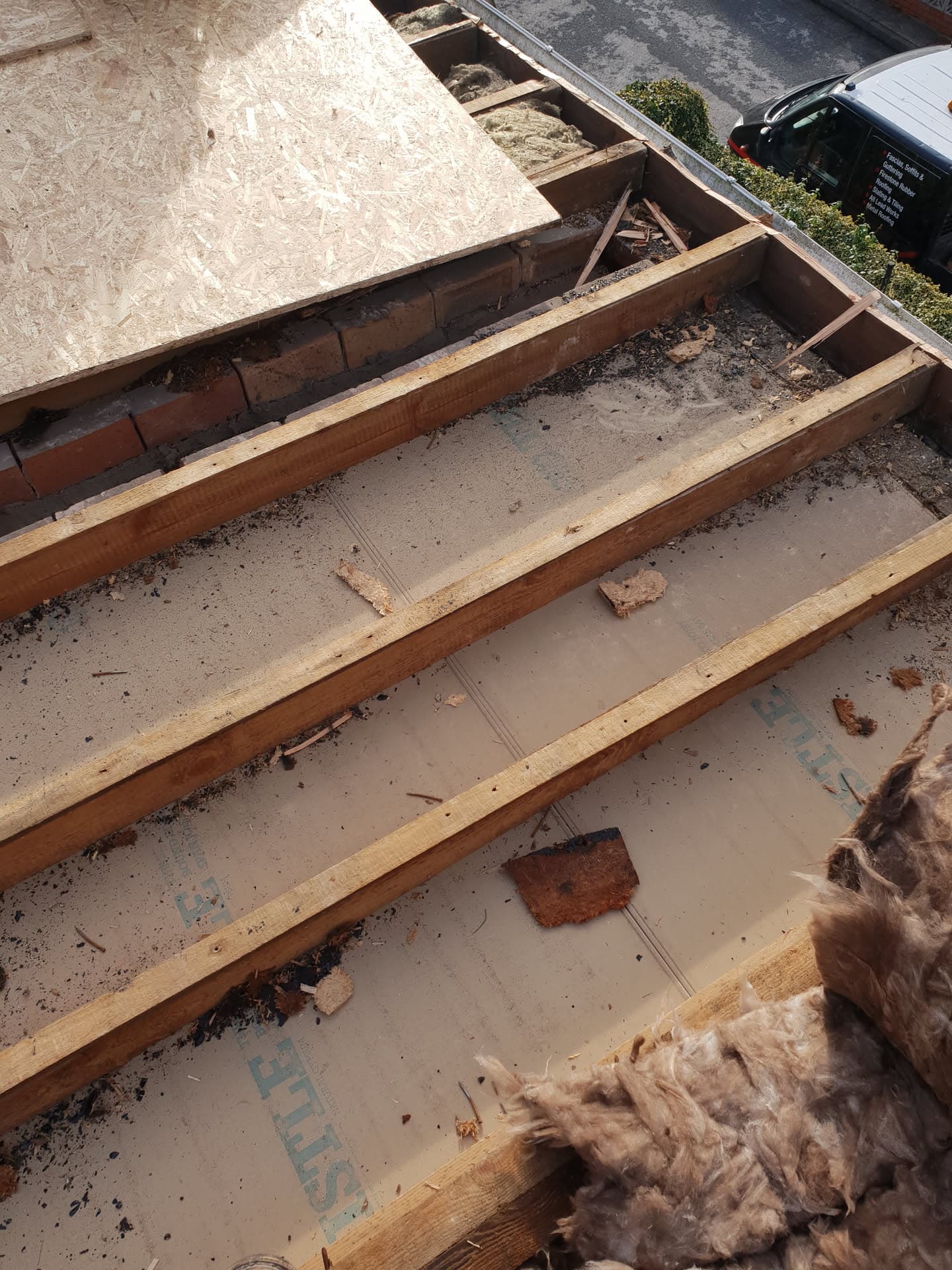 Flat roof stripped back to timber joists with old felt and insulation removed during renovation