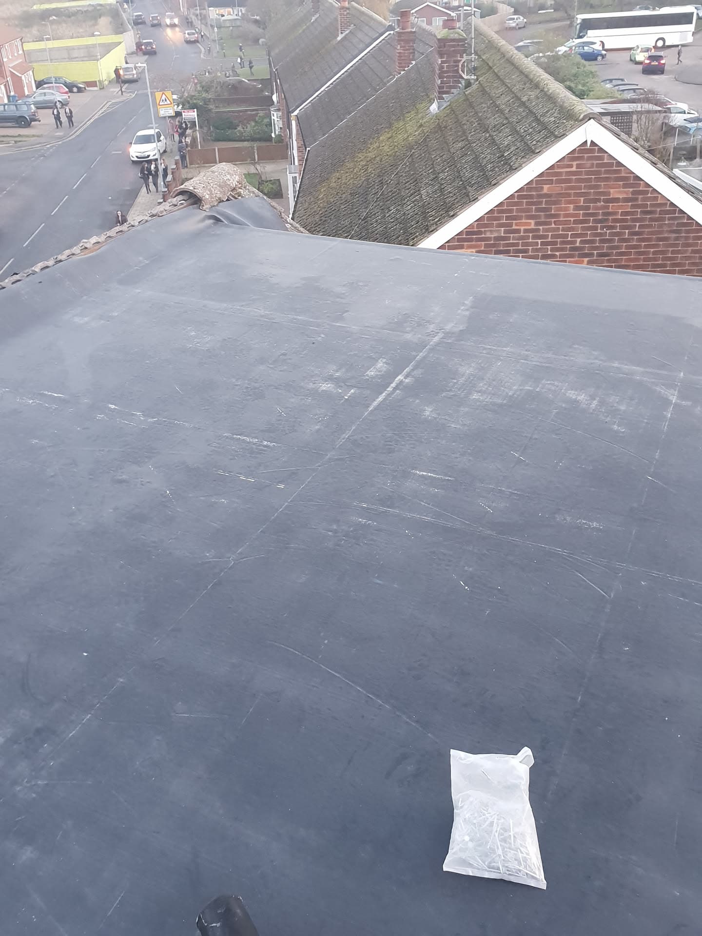 Completed flat roof with grey felt covering on residential property