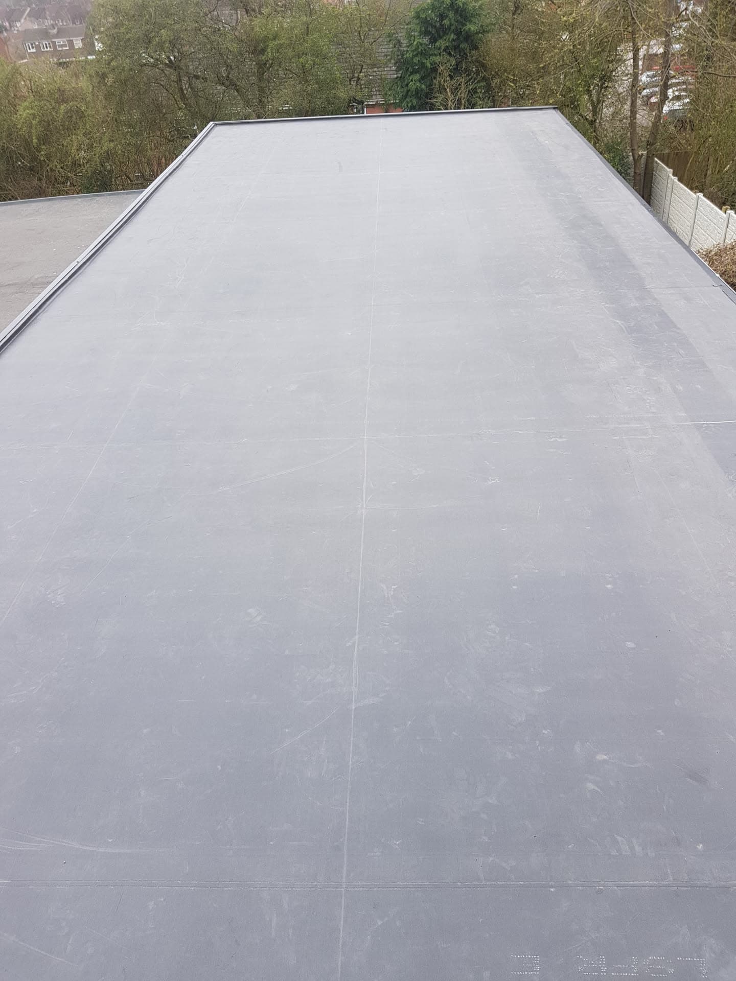 Grey flat roof with EPDM rubber membrane and metal trim edging