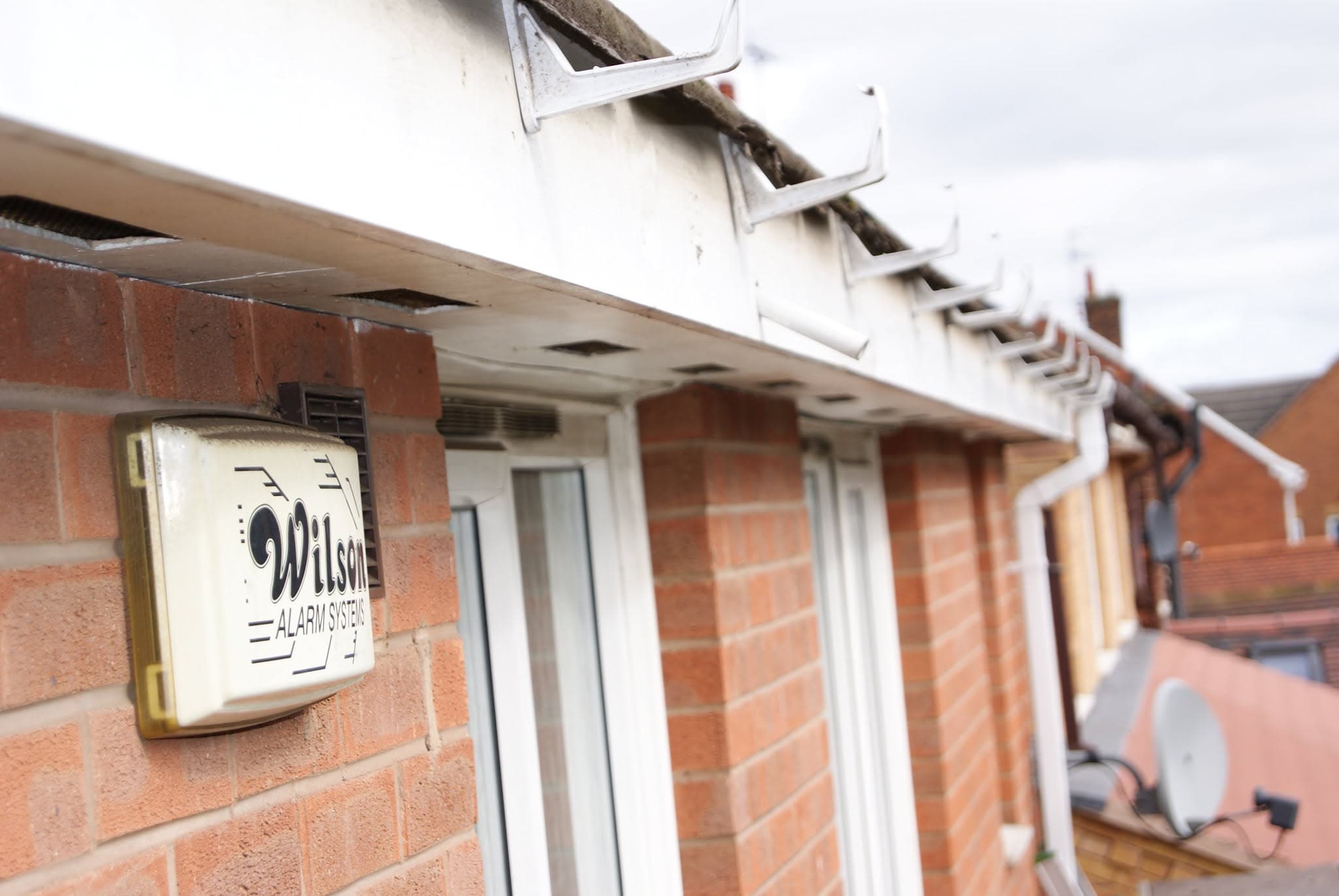 White fascia boards and soffits with brown guttering on brick terraced houses