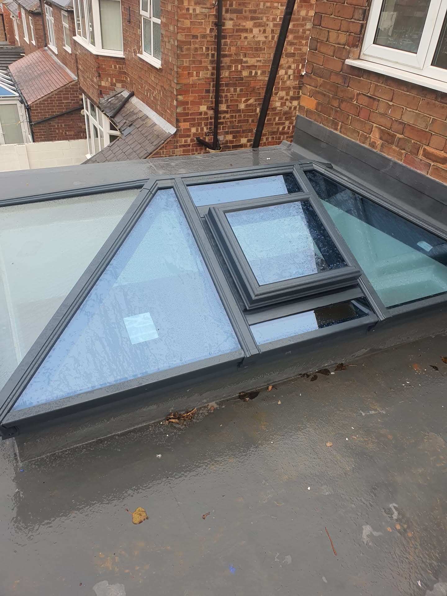 Flat roof with anthracite grey roof lantern and opening windows on residential extension