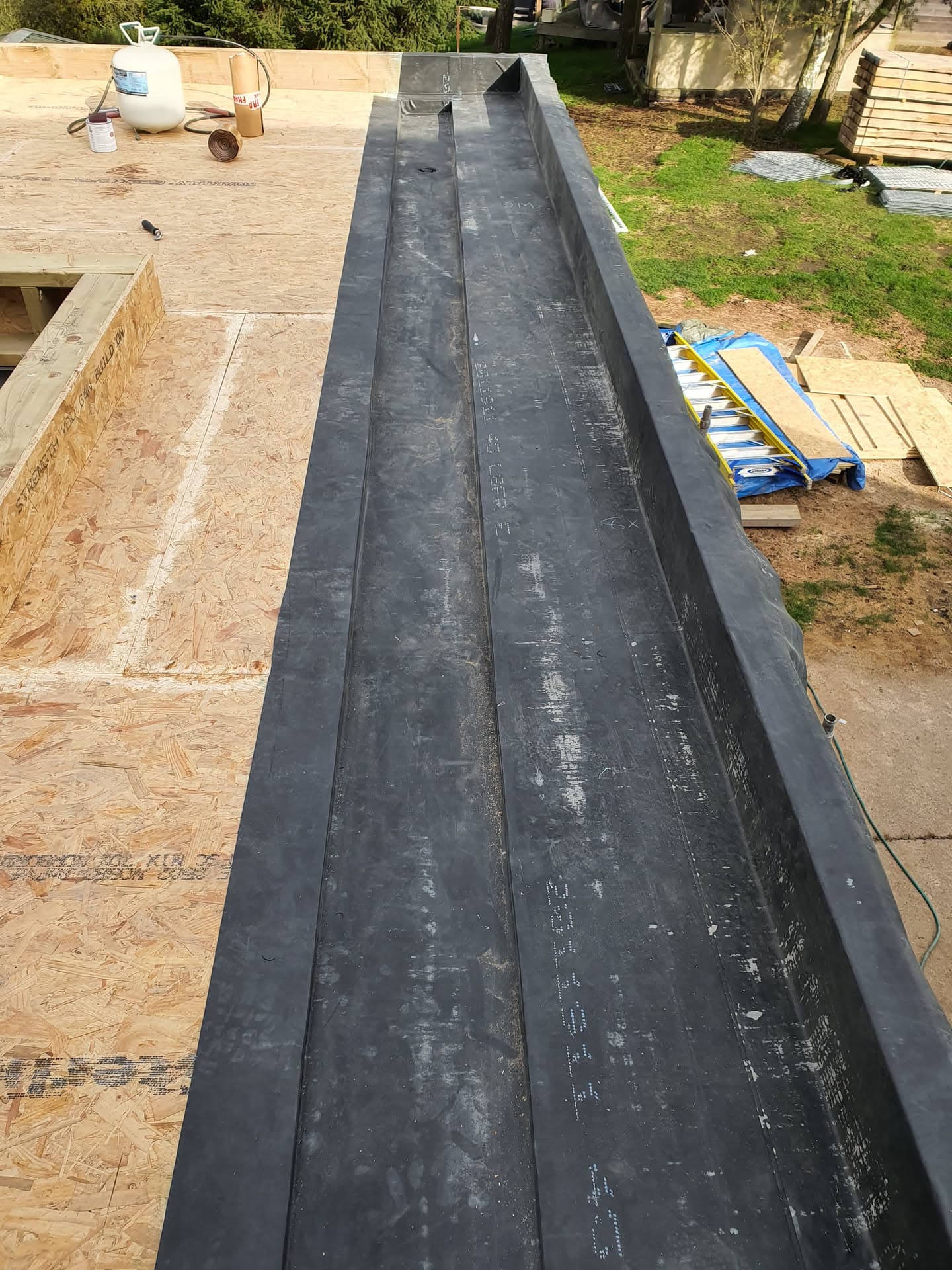 Flat roof with black EPDM rubber membrane installed on timber decking