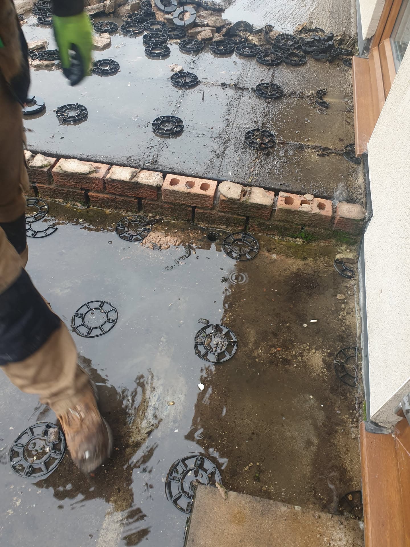 Flat roof installation in progress with support pedestals positioned on waterproofed surface