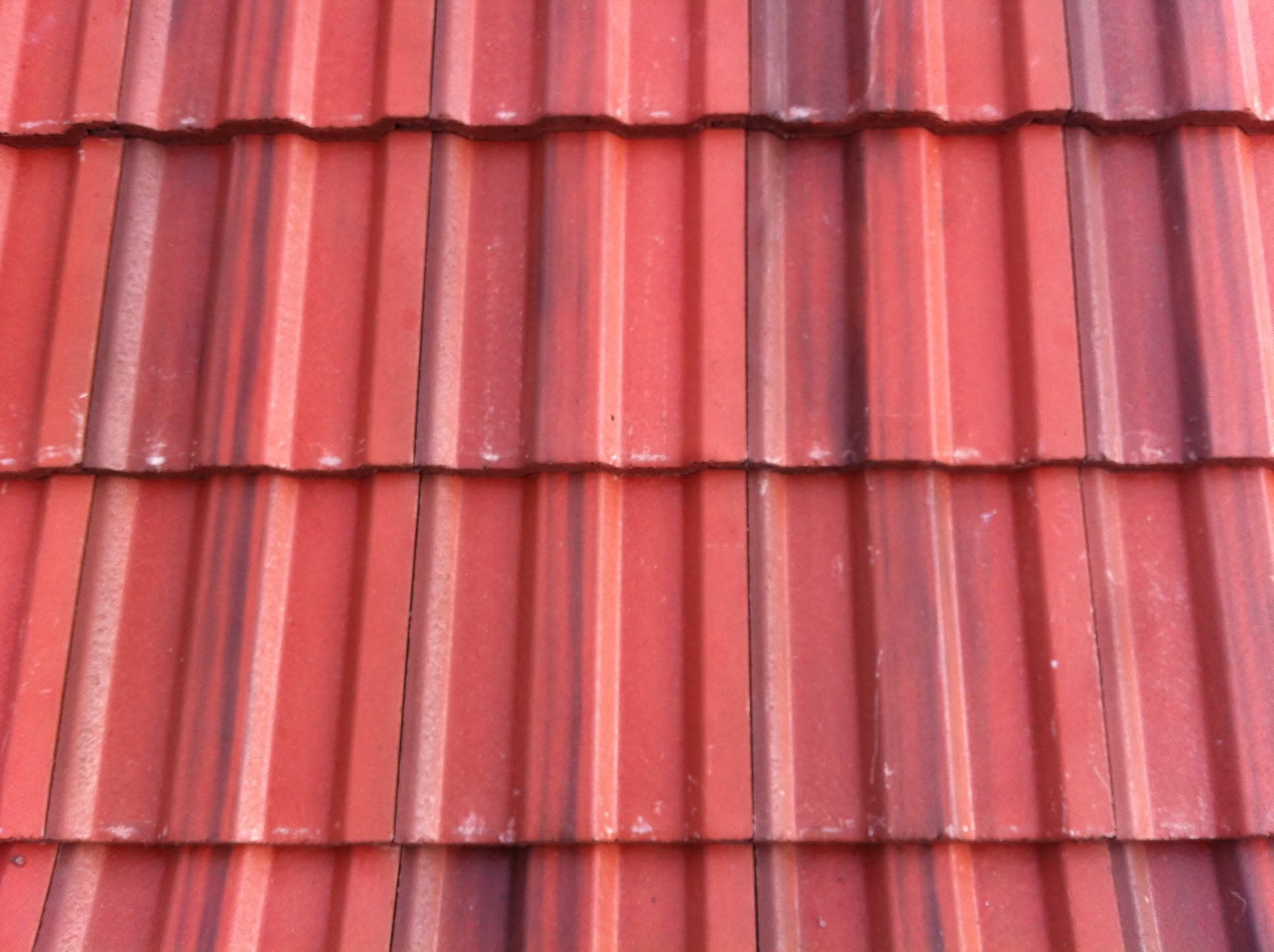 Red concrete interlocking roof tiles in overlapping rows